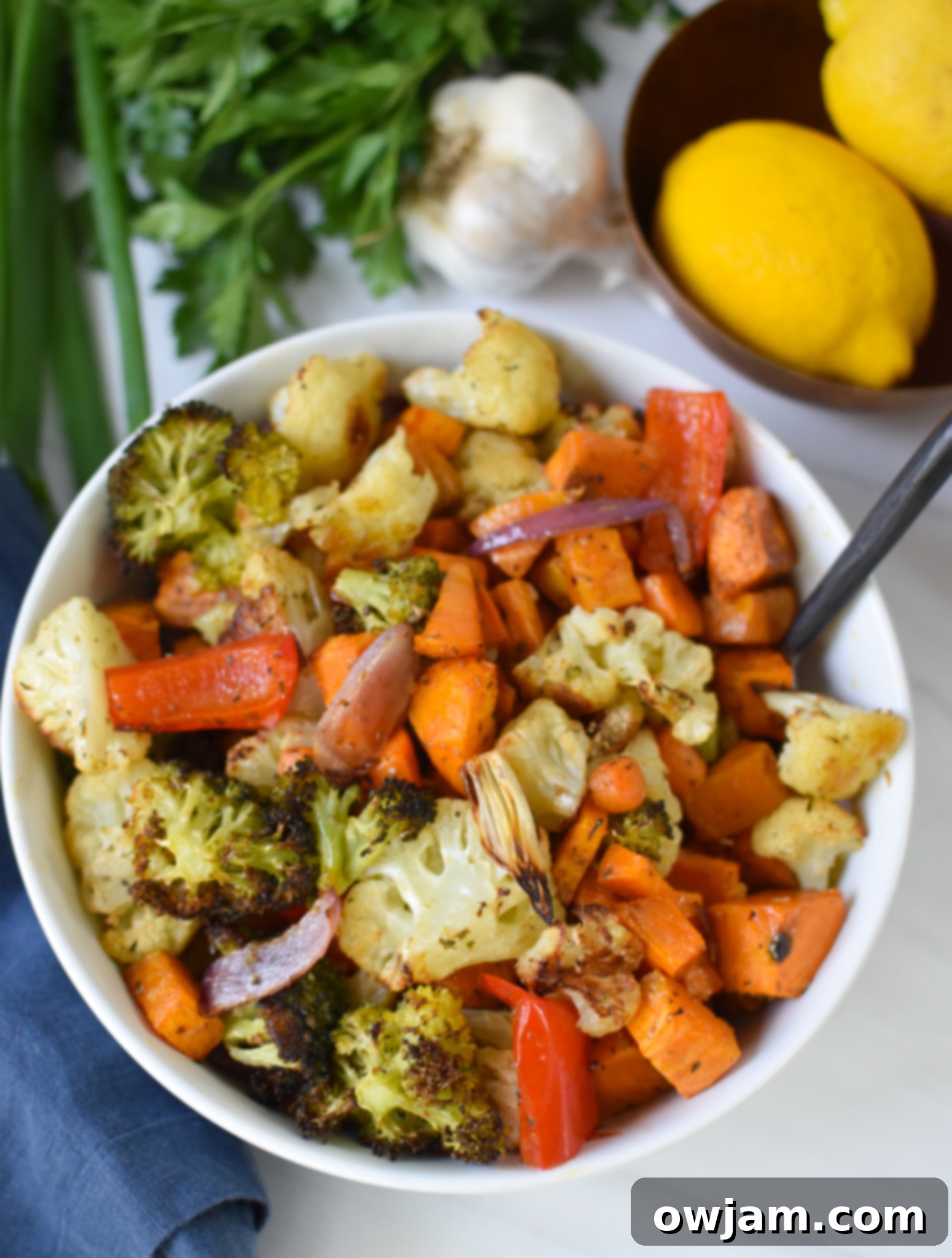 Roasted sweet potatoes and vegetables cooling in a bowl.