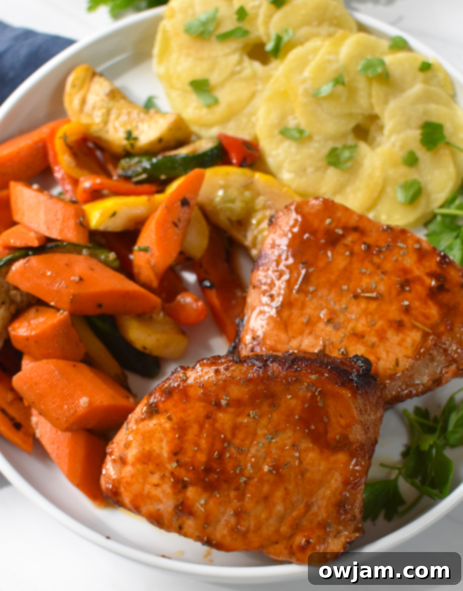 Air Fryer Boneless Pork Chops with vegetables and potatoes on plate. 