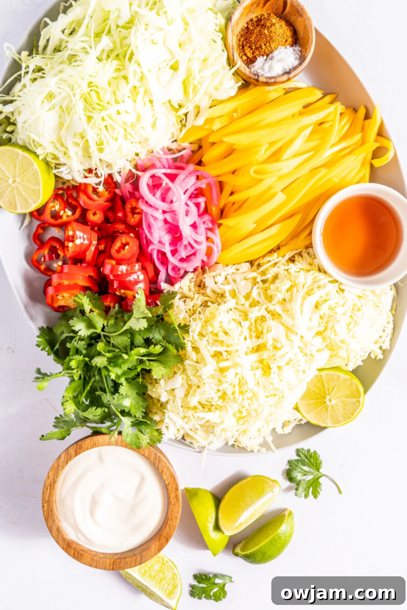 Fresh ingredients for Easy Caribbean Coleslaw Recipe laid out on a white surface.