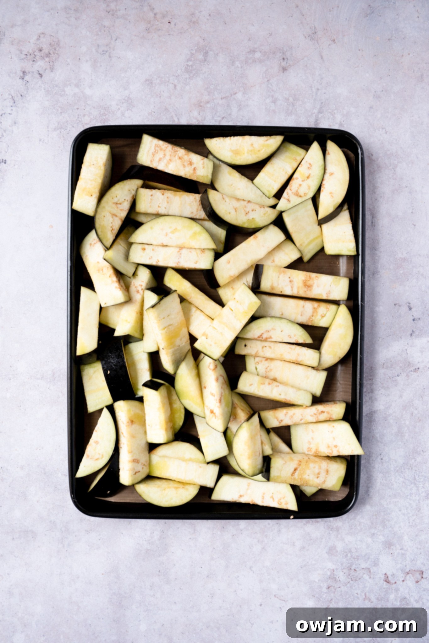 Eggplant halves seasoned and ready for roasting on a baking sheet for Easy Eggplant Curry.