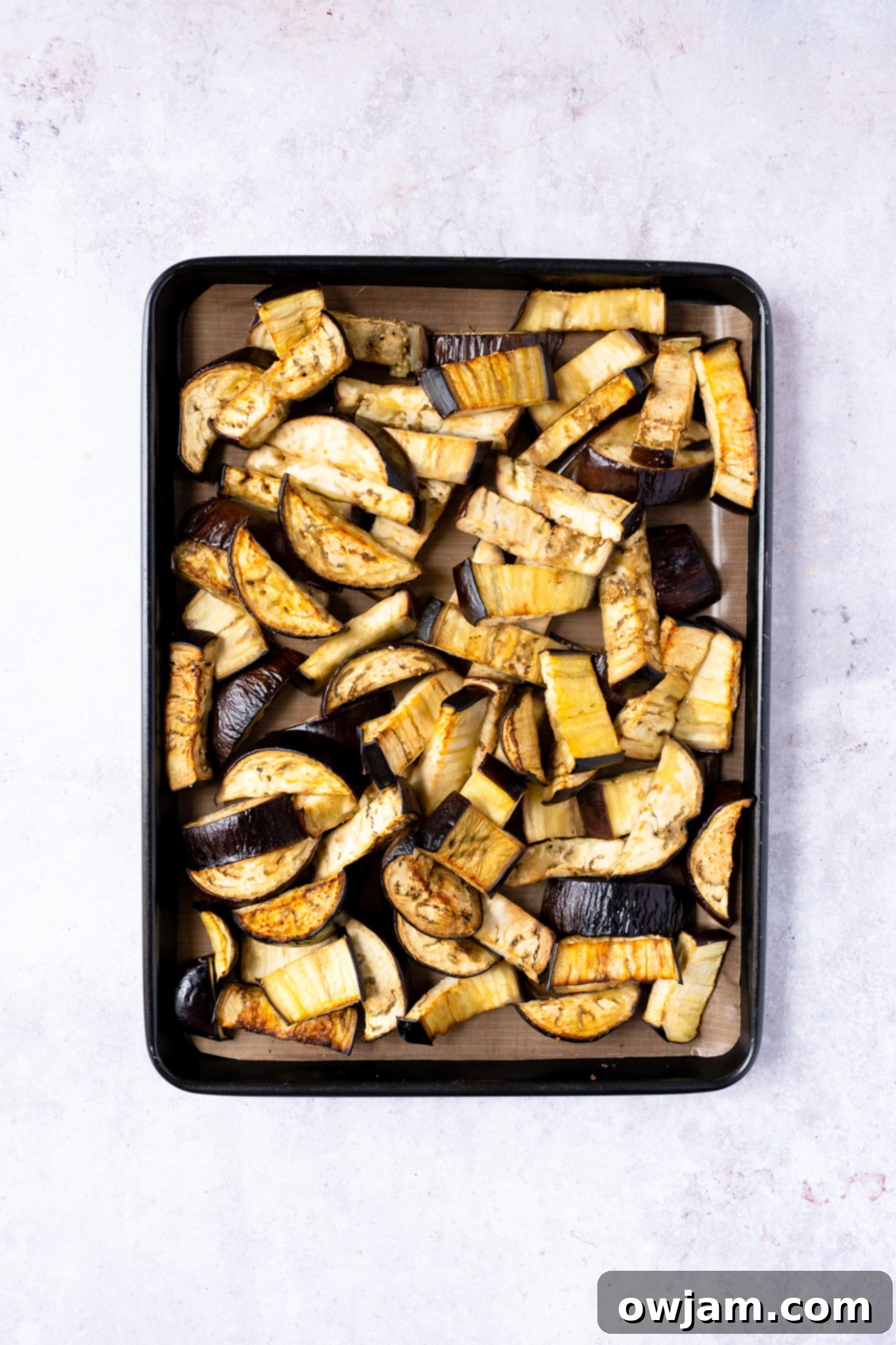 Roasted eggplant pieces cooling on a baking dish, ready to be added to the Easy Eggplant Curry sauce.