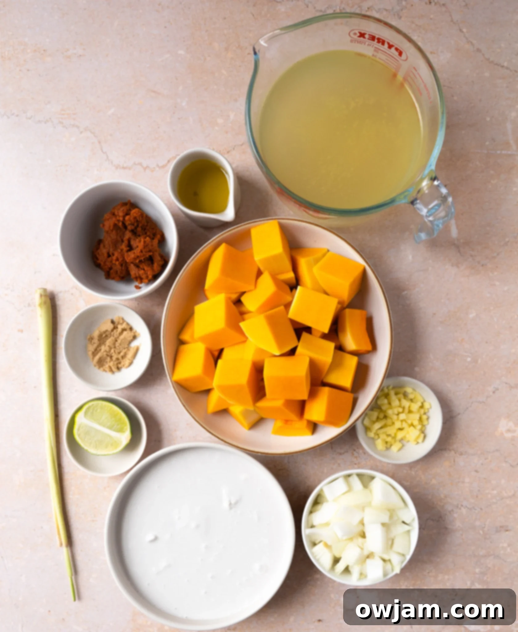 Autumn Ember Pumpkin Soup 3 Ingredients for Thai Roasted Pumpkin Soup laid out on a table: pumpkin, onion, ginger, red curry paste, coconut milk, stock, lemongrass, lime, brown sugar.