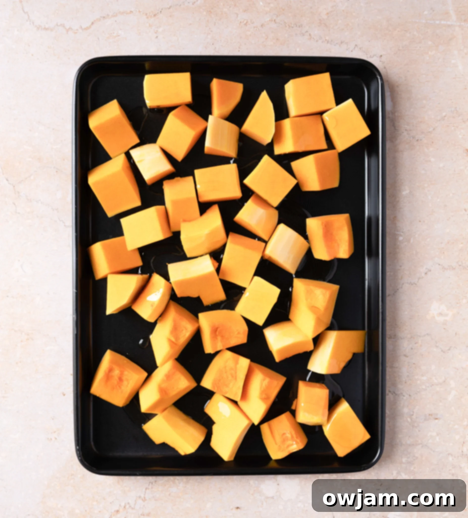 Autumn Ember Pumpkin Soup 5 Cubed pumpkin pieces on a baking sheet, ready for roasting for the soup.