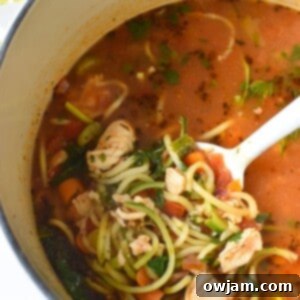 A top-down view of a bowl of Mediterranean Fish Soup, garnished with fresh herbs, ready to be enjoyed.