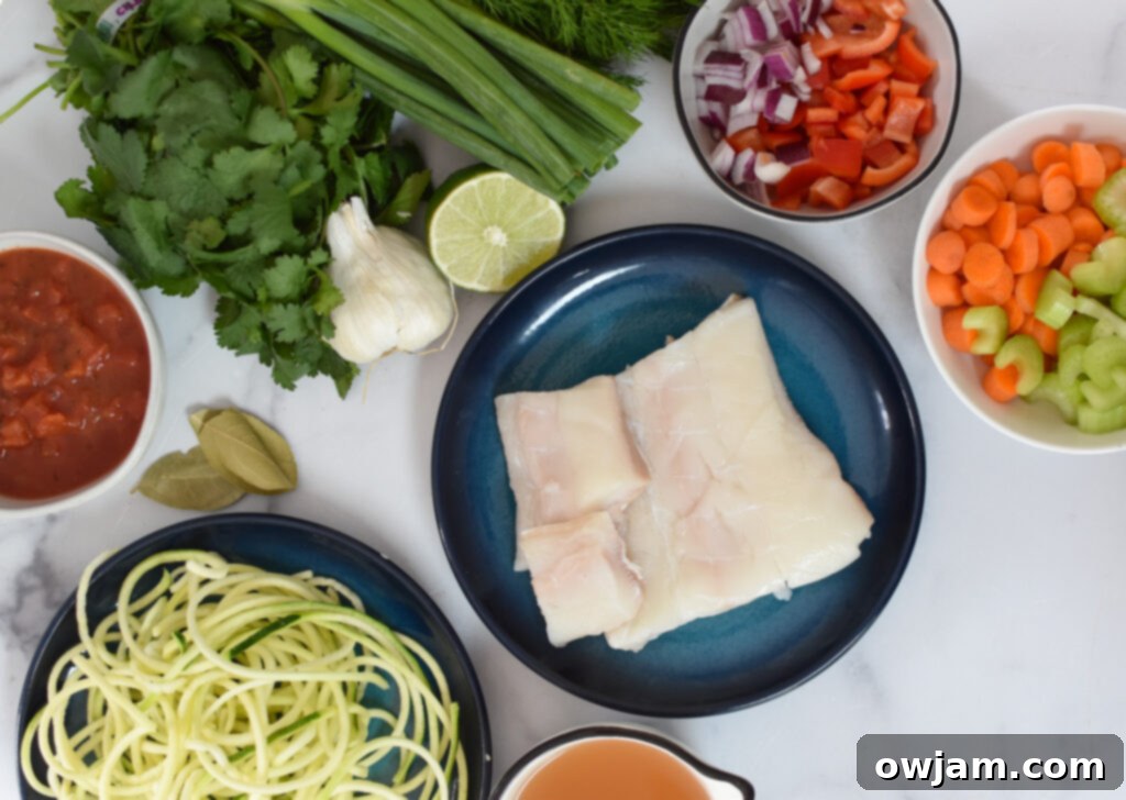 A vibrant selection of fresh ingredients for Mediterranean Fish Soup laid out on a cutting board, including fresh herbs, colorful vegetables, and fish fillets.