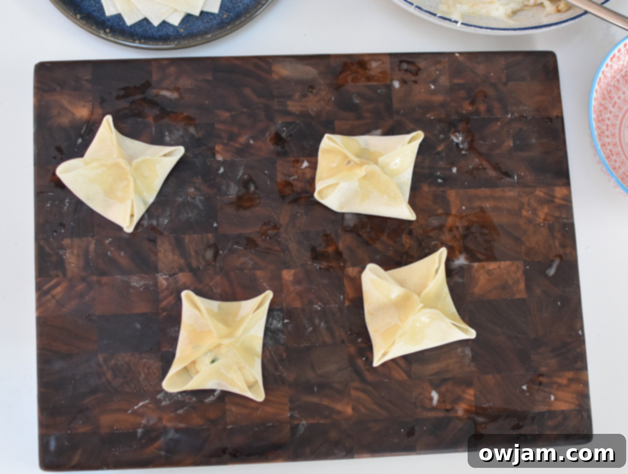 Crispy Air Fryer Crab Rangoon 7 Multiple Air Fryer Crab Rangoon wontons, folded and brushed with oil, waiting to be cooked to crispy perfection.