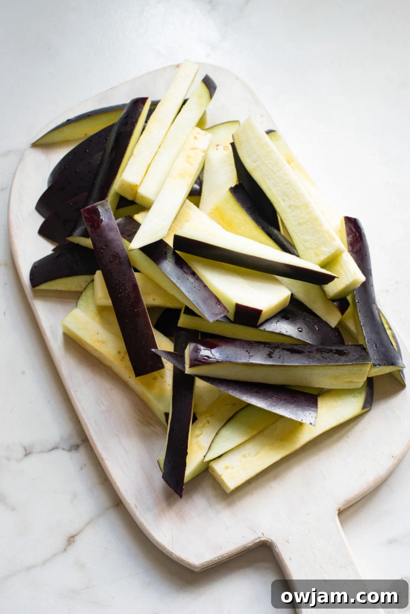 Crispy Air Fryer Eggplant Fries 5 Fresh eggplant carefully cut into uniform french fry sticks, ready for breading.