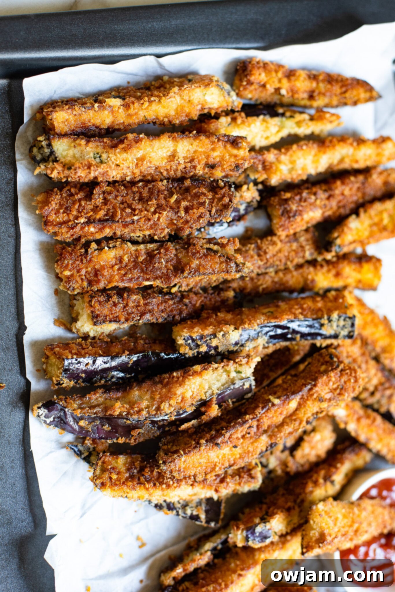 Crispy Air Fryer Eggplant Fries 9 A batch of golden Air Fryer Eggplant Fries arranged on a baking sheet, showcasing their perfect crispness and readiness to be served.
