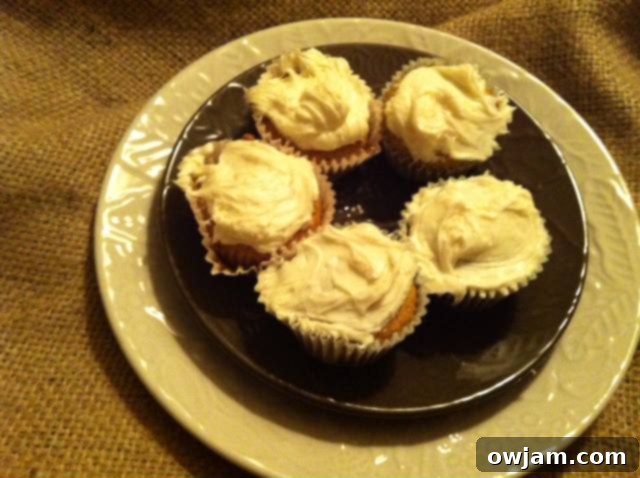 A batch of five freshly baked carrot cupcakes, golden brown and ready for frosting