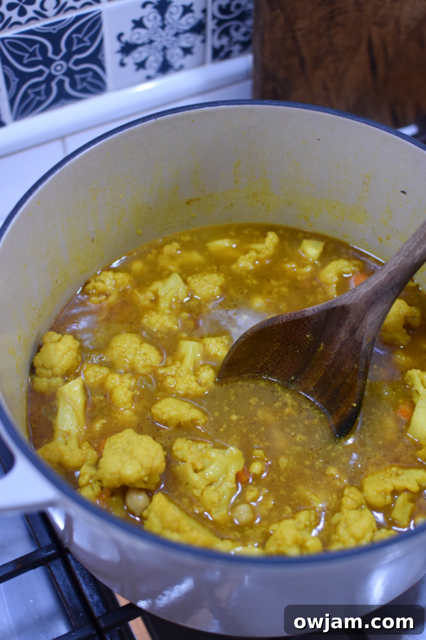 Cauliflower and broth simmering in a pot, ready for blending into creamy cauliflower soup.