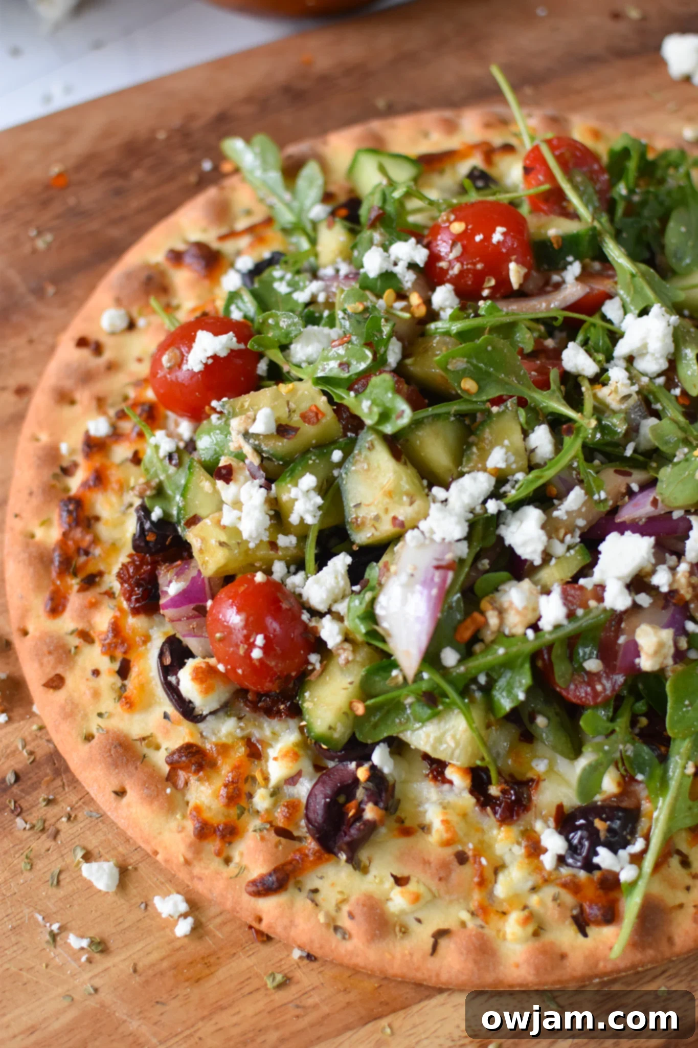 Greek Pizza on a cutting board.