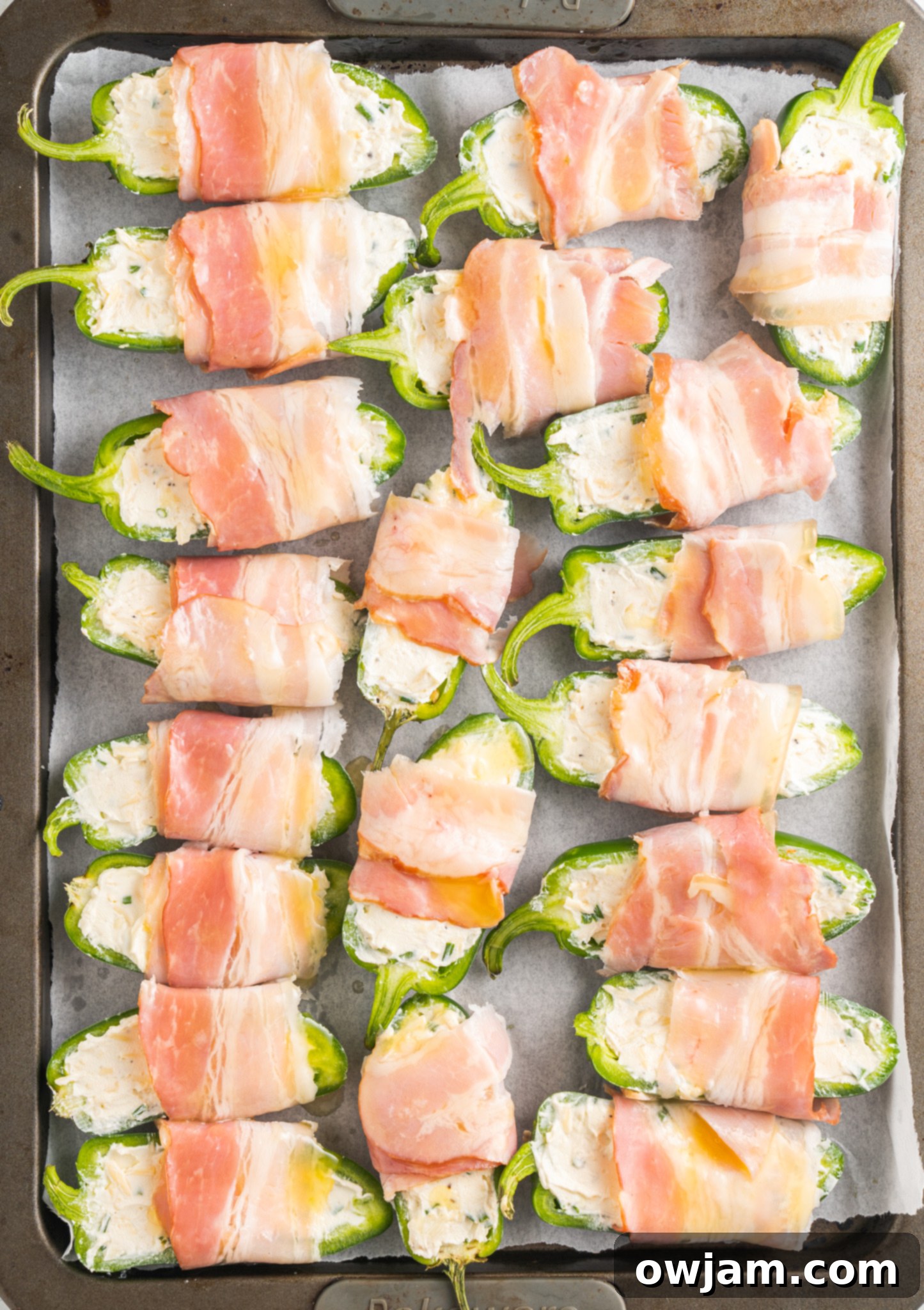 Jalapeño Poppers with Bacon on a baking sheet.