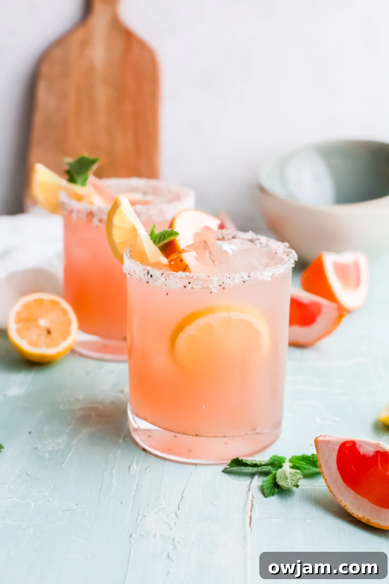 Tangy Grapefruit Paloma 8 Grapefruit Paloma Cocktail served in a glass, garnished with a sprig of mint and a grapefruit wedge.