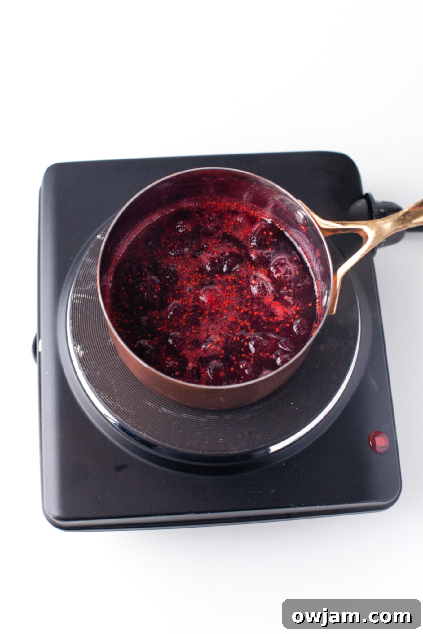 Fresh cranberries simmering in a pot for cranberry syrup.