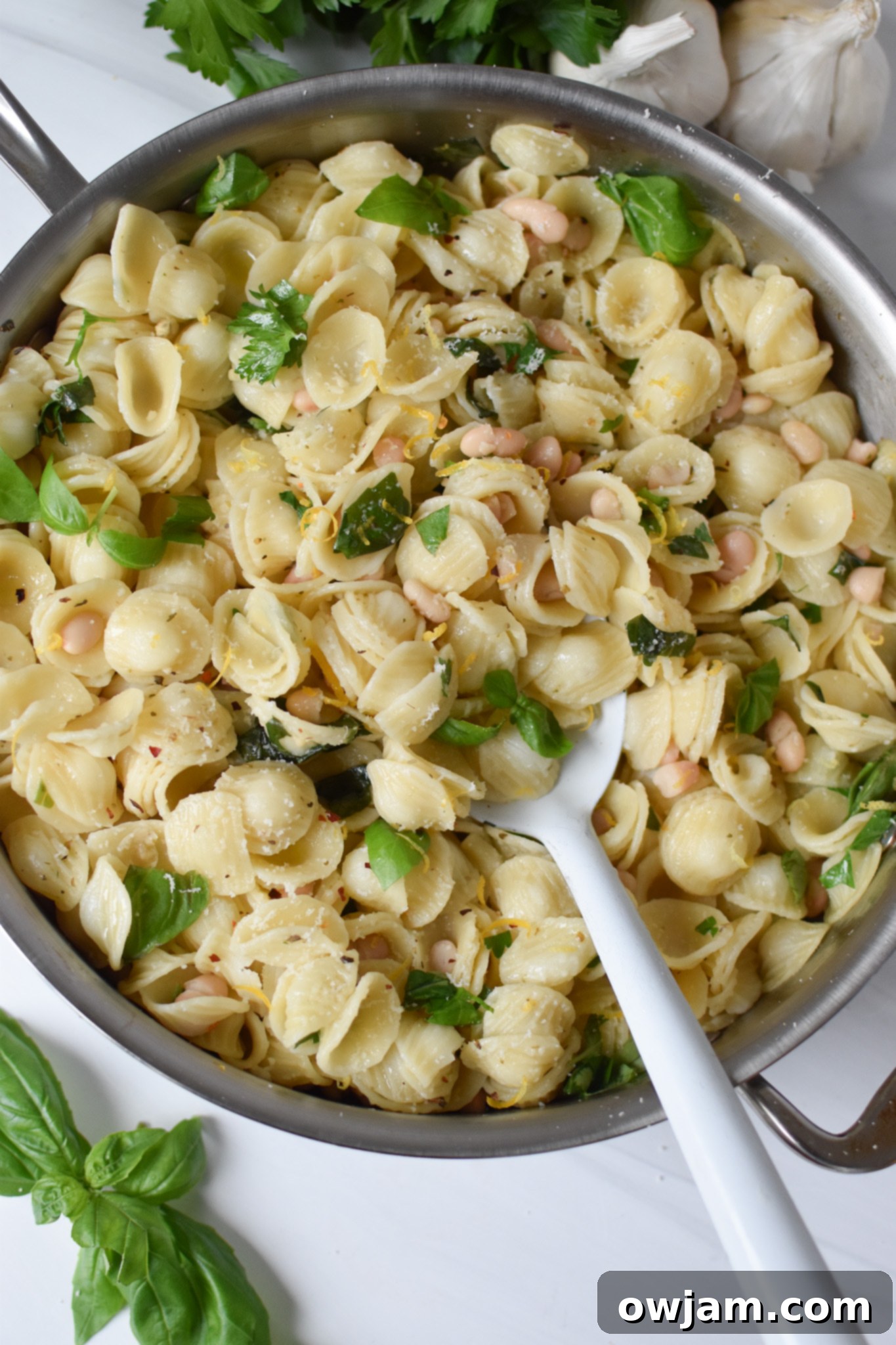 Lemon Basil Pasta in a skillet with a white spoon. 