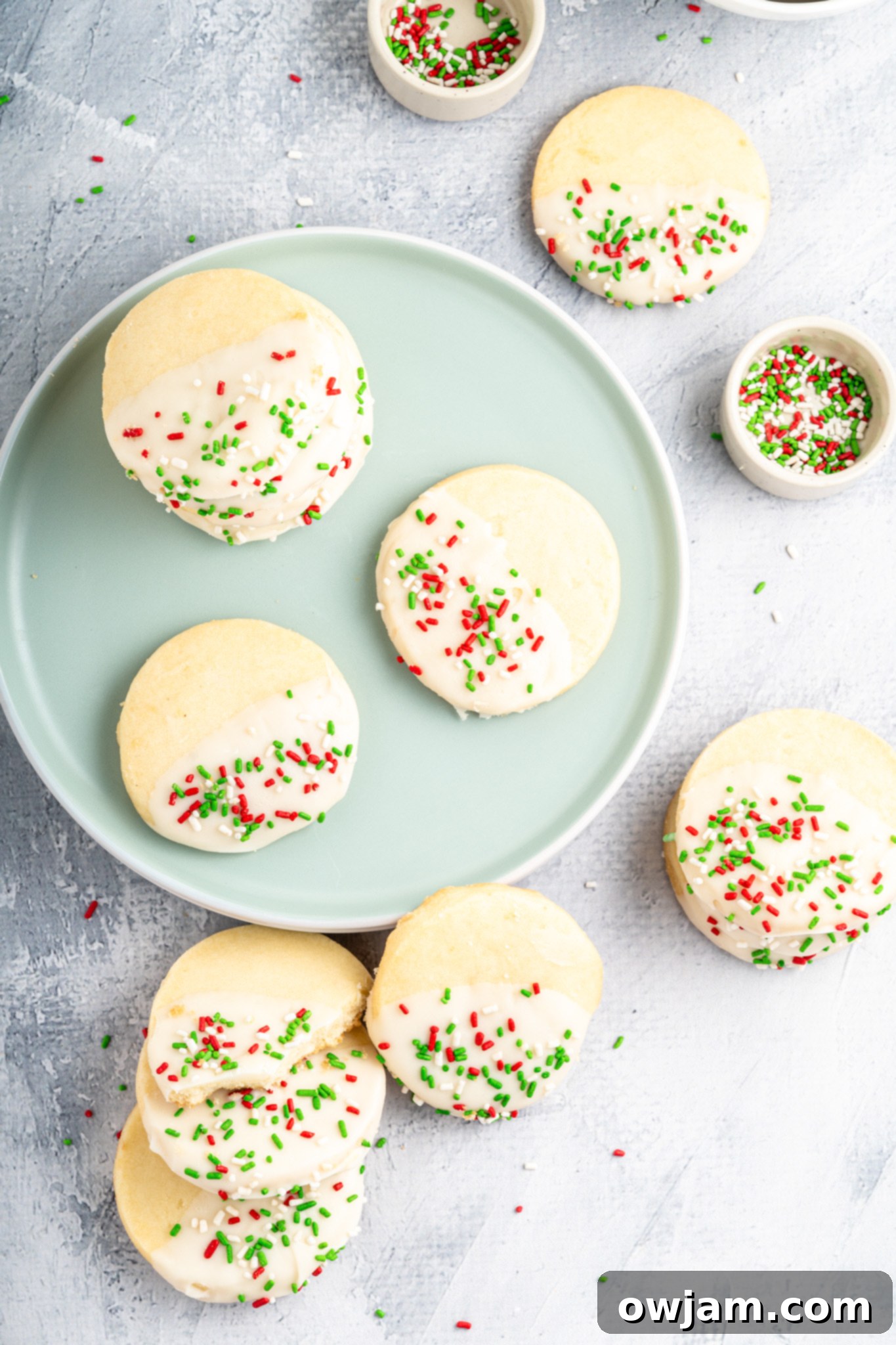 A festive plate of decorated Christmas Shortbread Cookies, featuring white chocolate and sprinkles, ready to be served.