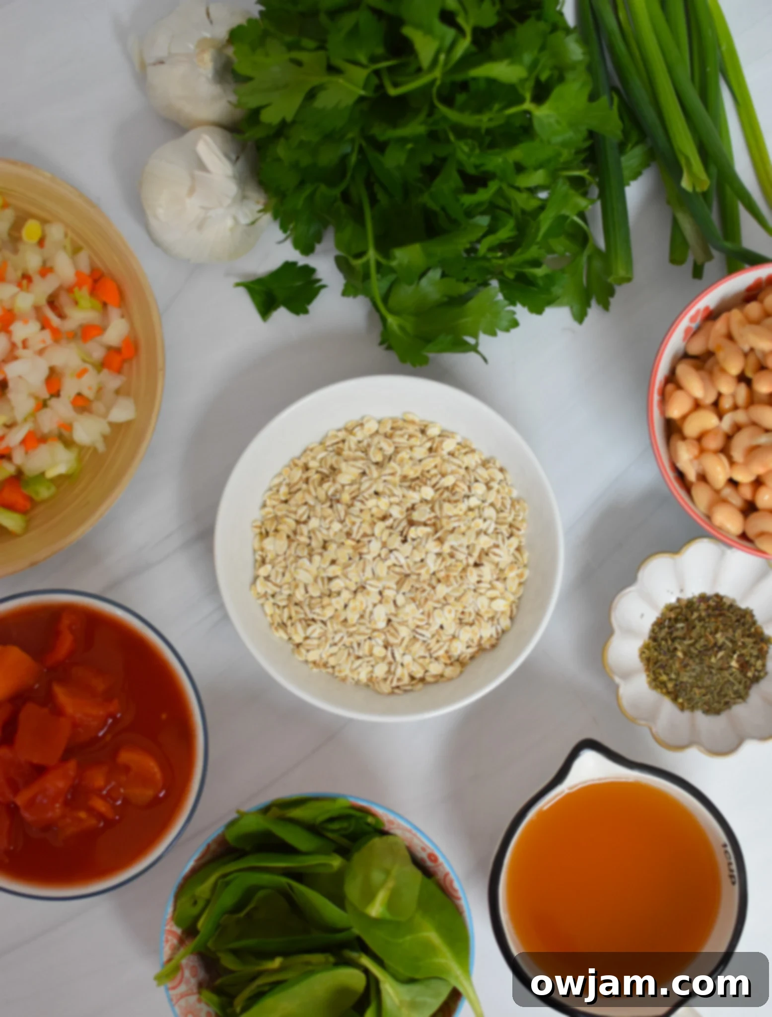 Hearty Vegetable Barley Bowl 4 A flat lay of fresh ingredients laid out for Vegetable Barley Soup, including carrots, celery, onion, garlic, canned tomatoes, and dried spices.