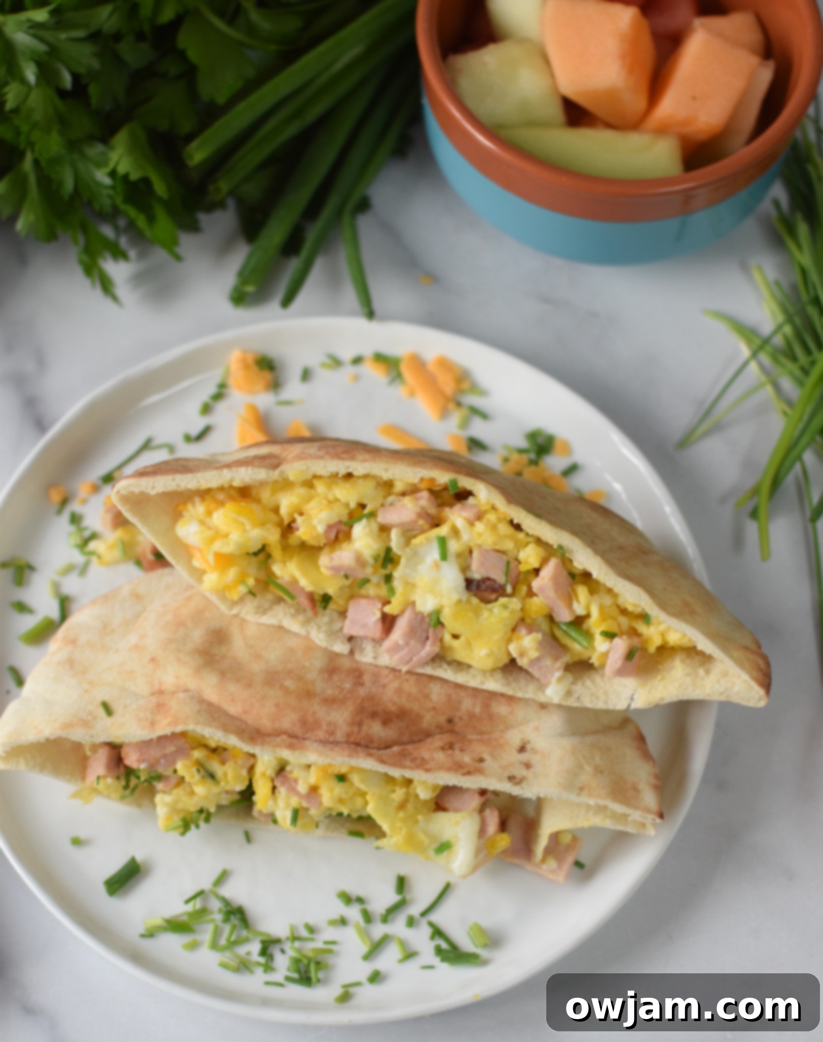 A freshly made Breakfast Pita Recipe served on a pristine white plate, garnished with a sprinkle of herbs.