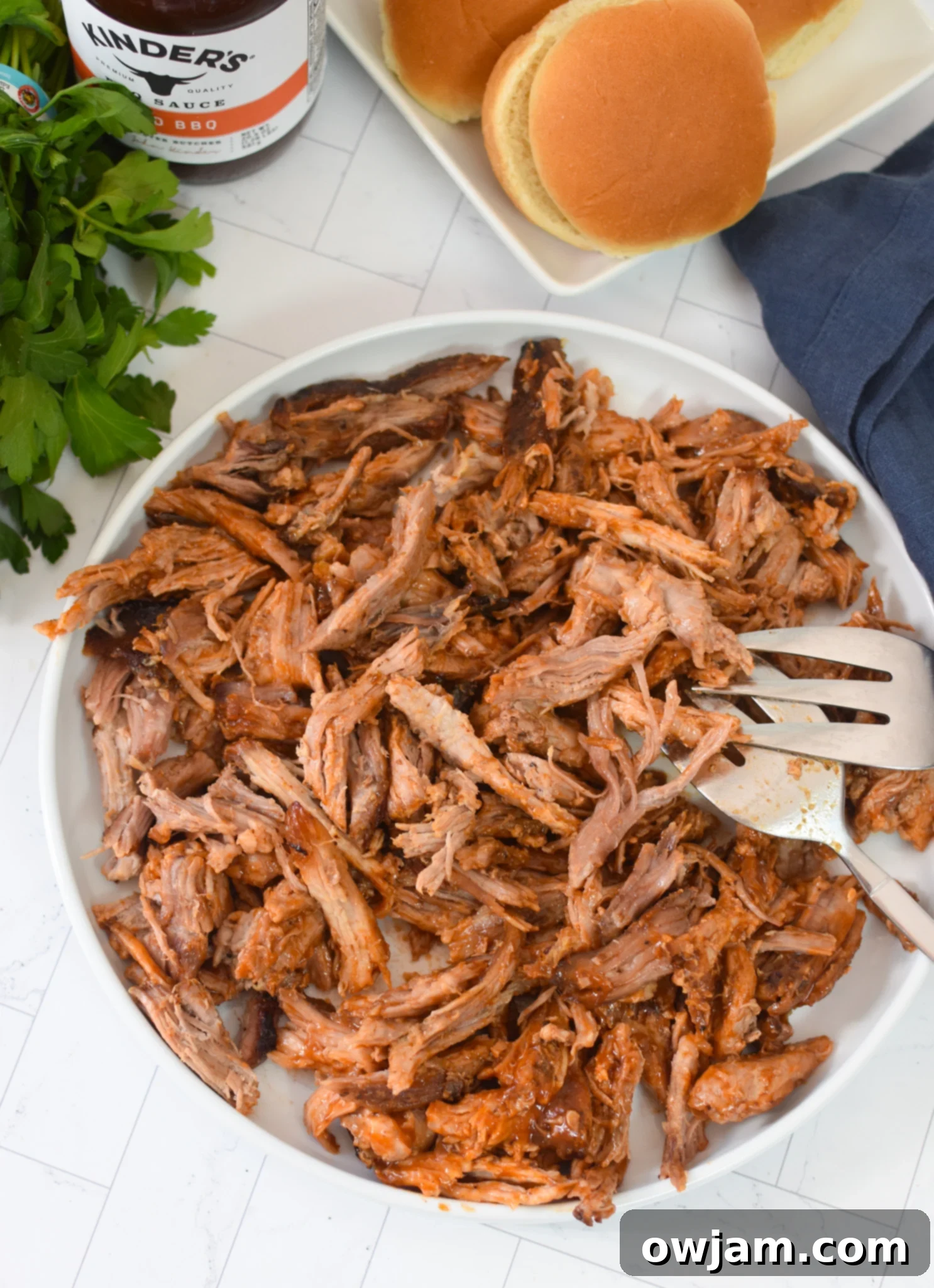 Effortless Oven Pulled Pork Perfection 2 Oven-roasted Boston butt with two forks for shredding, ready for serving as pulled pork.