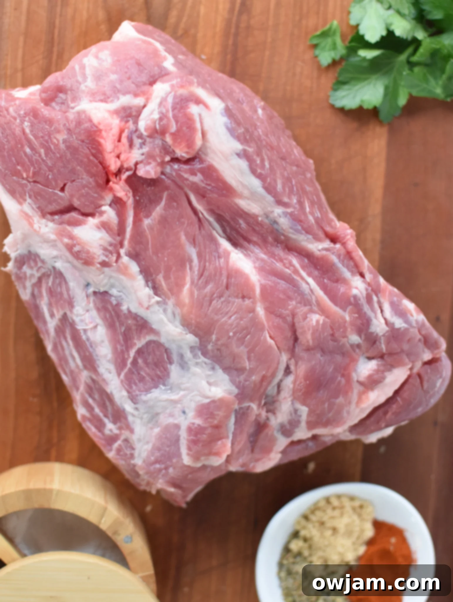 Oven Roasted Boston Butt Pulled Pork Perfection 3 Boston butt ingredients including a raw pork butt, spices, and an assortment of fresh herbs