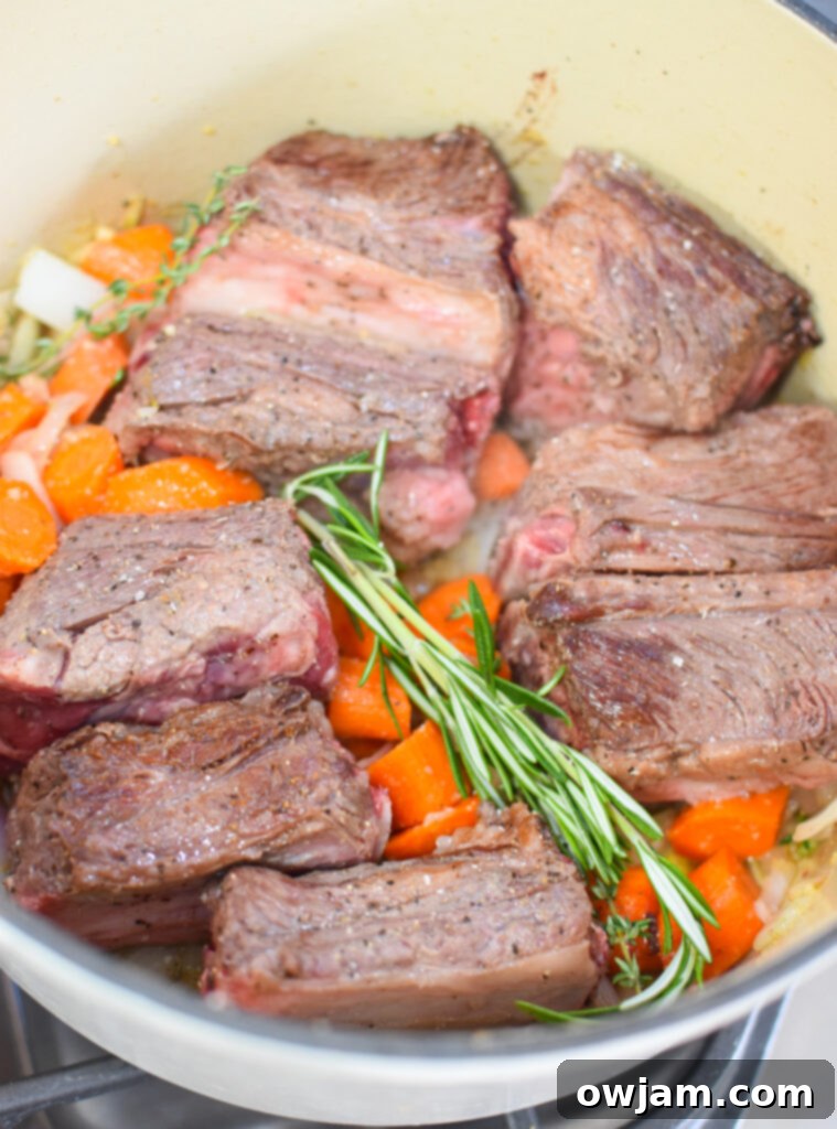 Festive Cranberry Braised Short Ribs 7 Cranberry Braised Short Ribs Recipe showing vegetables sautéing in the Dutch oven after searing the beef.
