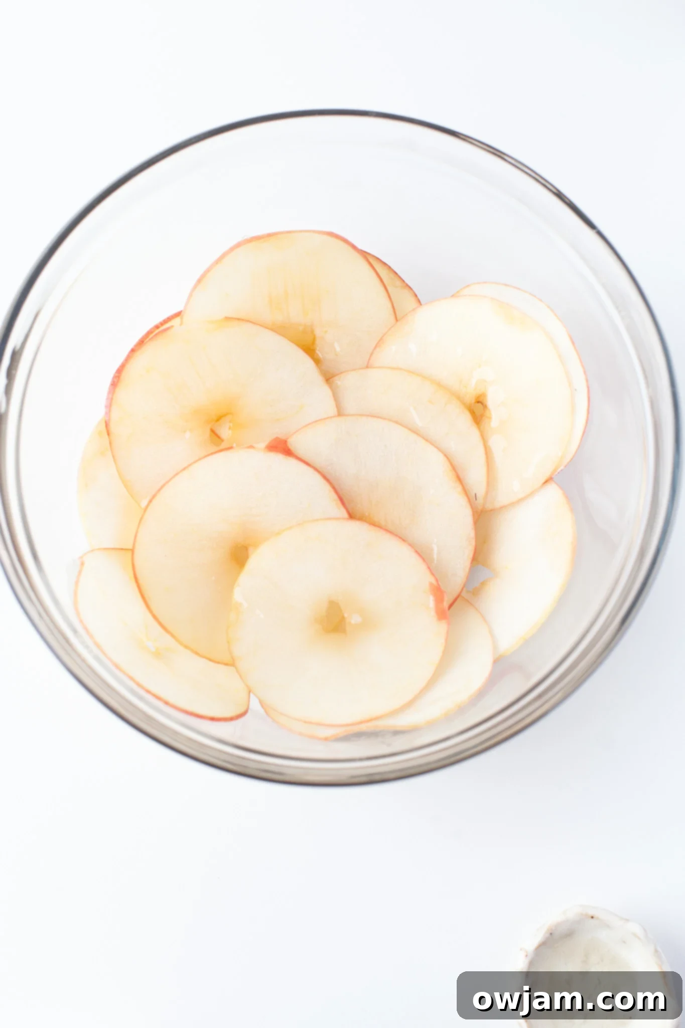 Perfectly Crispy Air Fryer Apple Slices 6 Easy Air Fryer Apple Chips: thinly sliced apples in a clear mixing bowl, ready for seasoning.