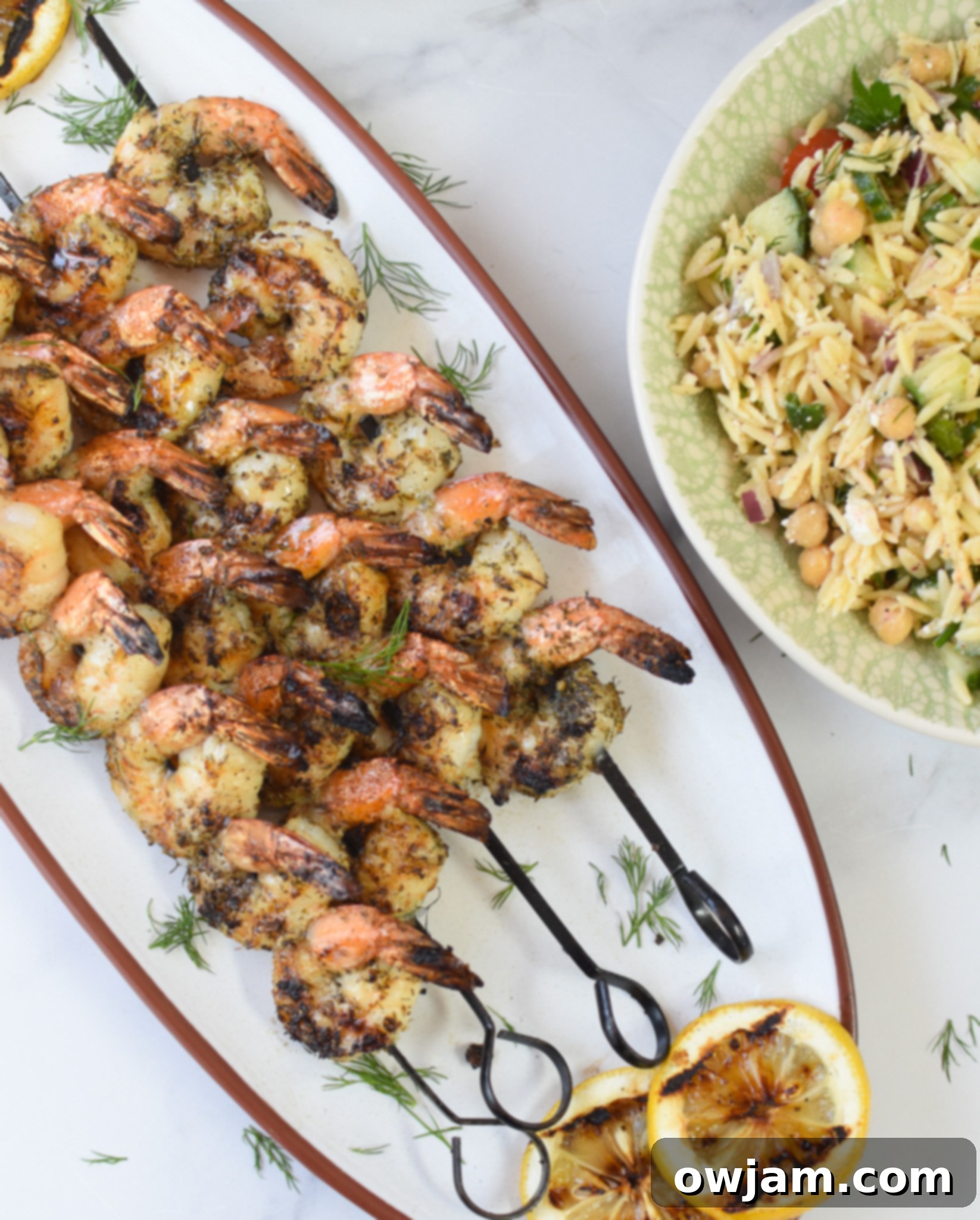Greek Shrimp Marinade on a white platter with orzo salad.