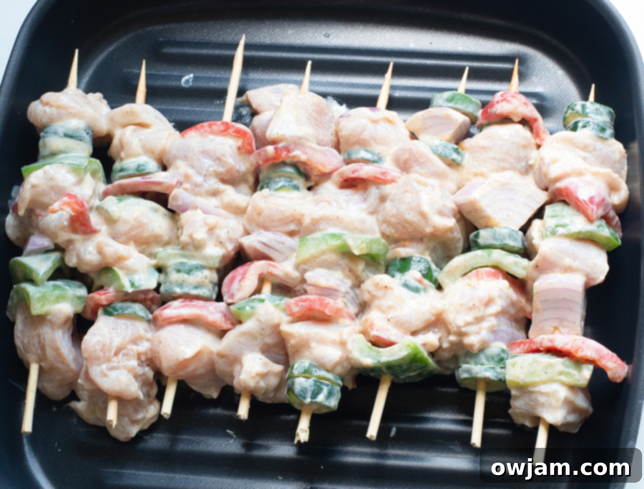 Zesty Greek Chicken Kabobs 7 Greek Marinated Chicken Kabobs with Lemon grilling on hot grates.