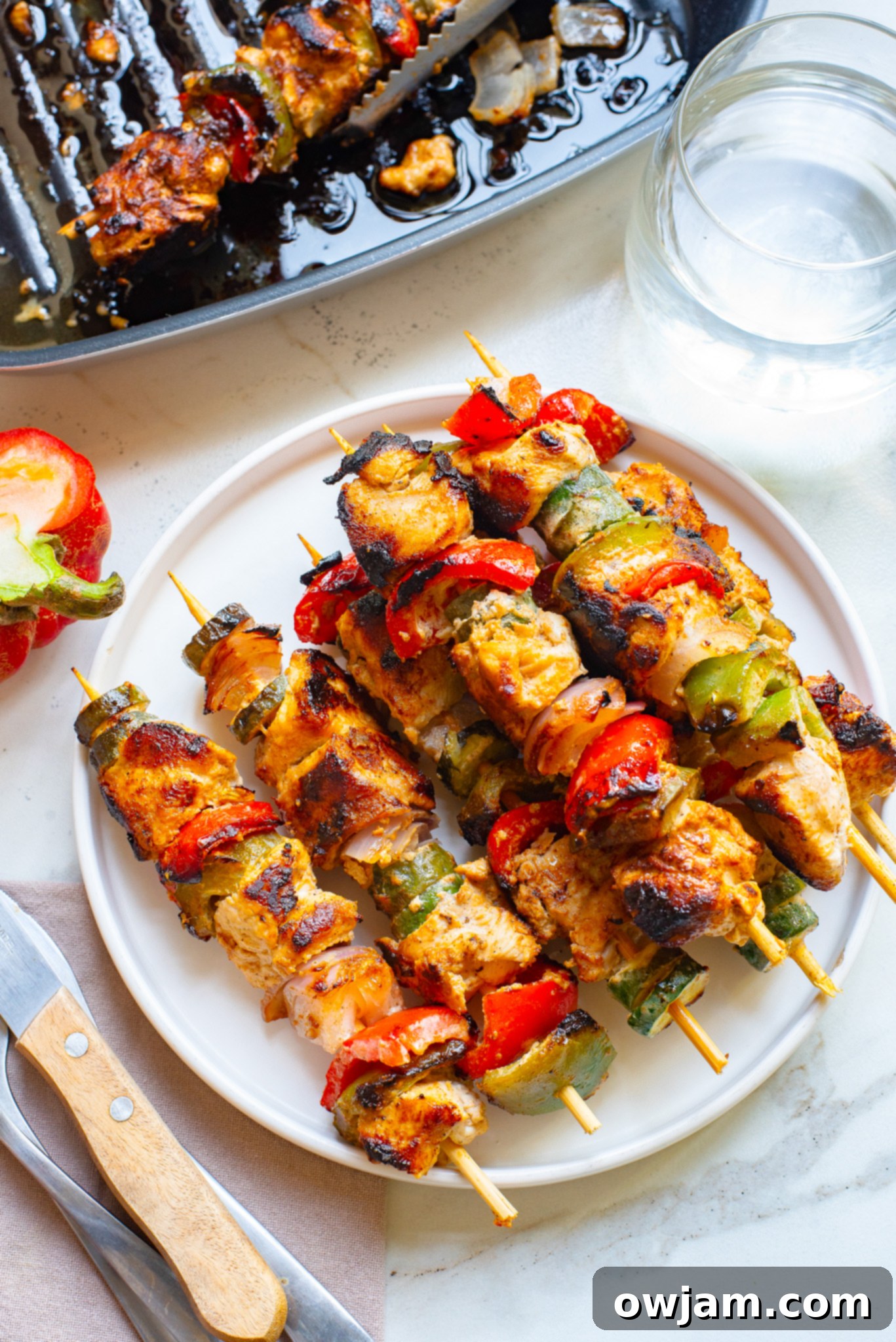 Zesty Greek Chicken Kabobs 8 Served Greek Marinated Chicken Kabobs with Lemon on a white platter.