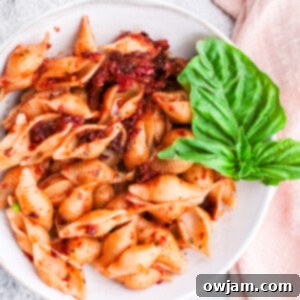 Sun-Dried Tomato Pesto Pasta in a bowl with a basil leaf.