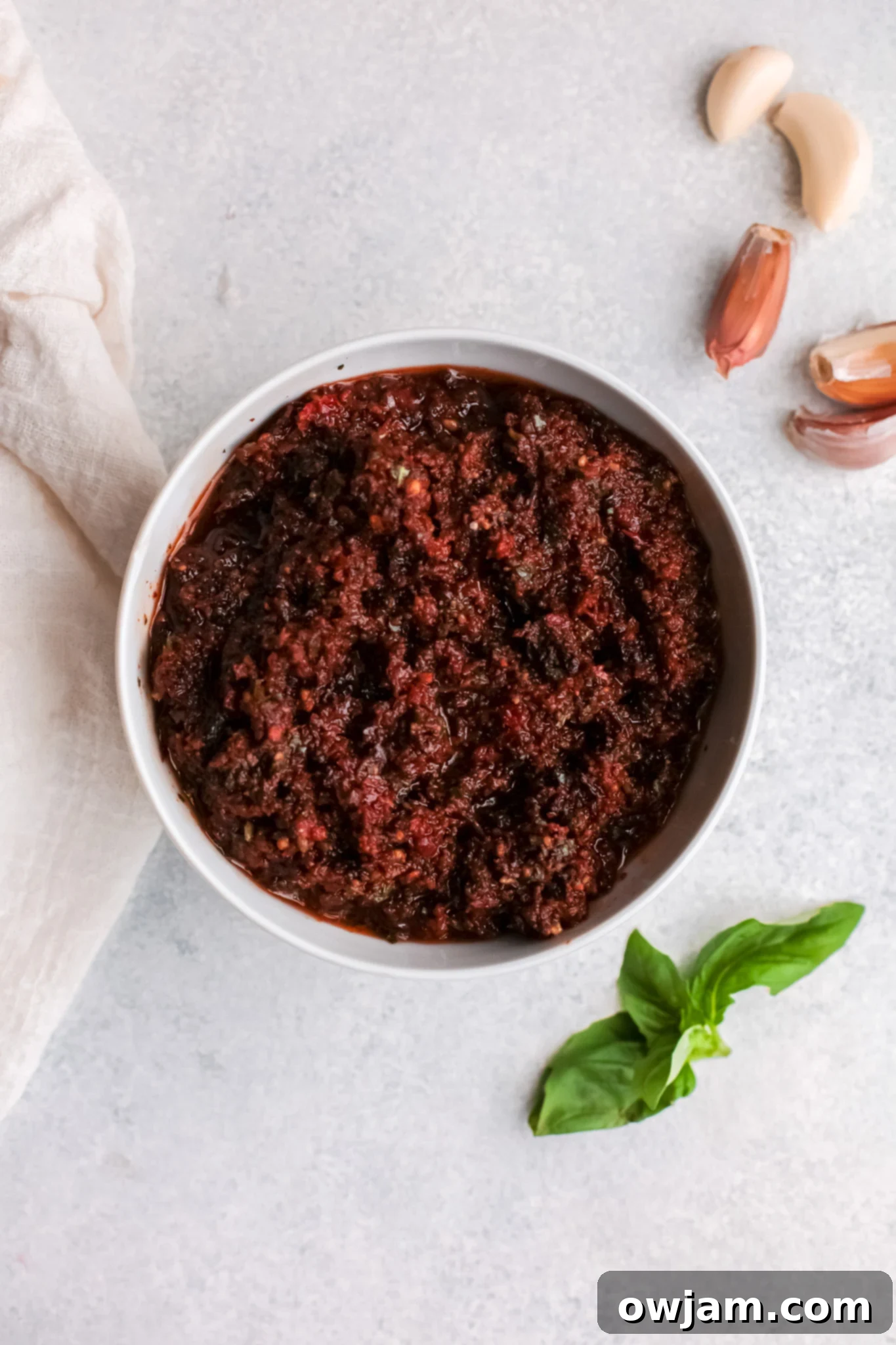 The freshly made Sun-Dried Tomato Pesto in a bowl, smooth and vibrant, ready to be mixed with pasta.