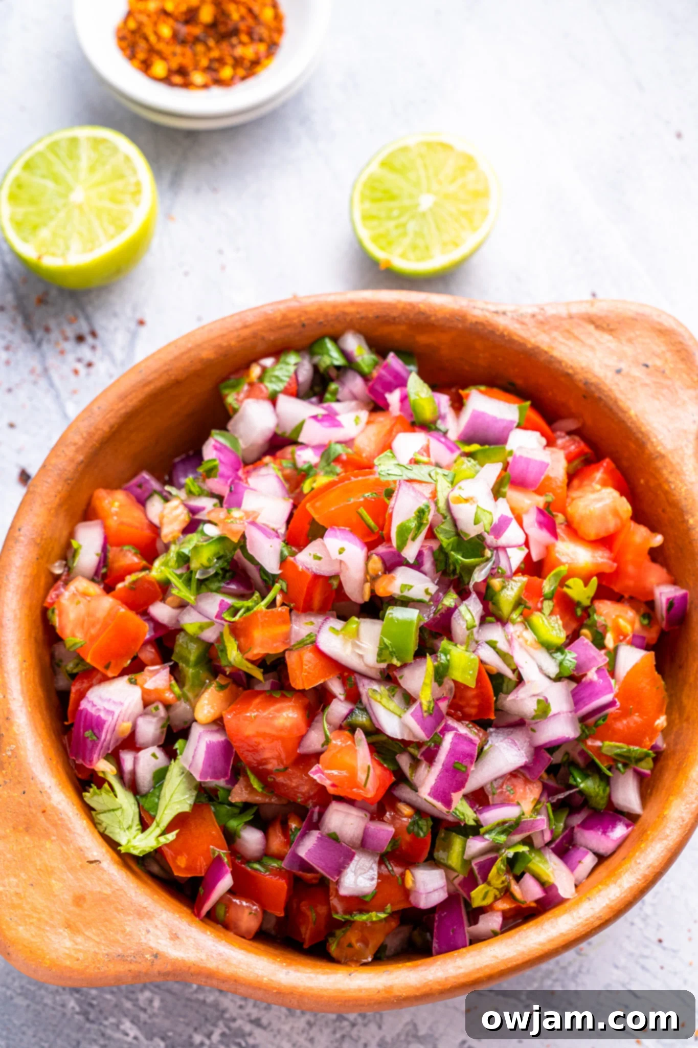 Fresh Homemade Pico de Gallo 2 Homemade Pico de Gallo in a tan colored bowl.