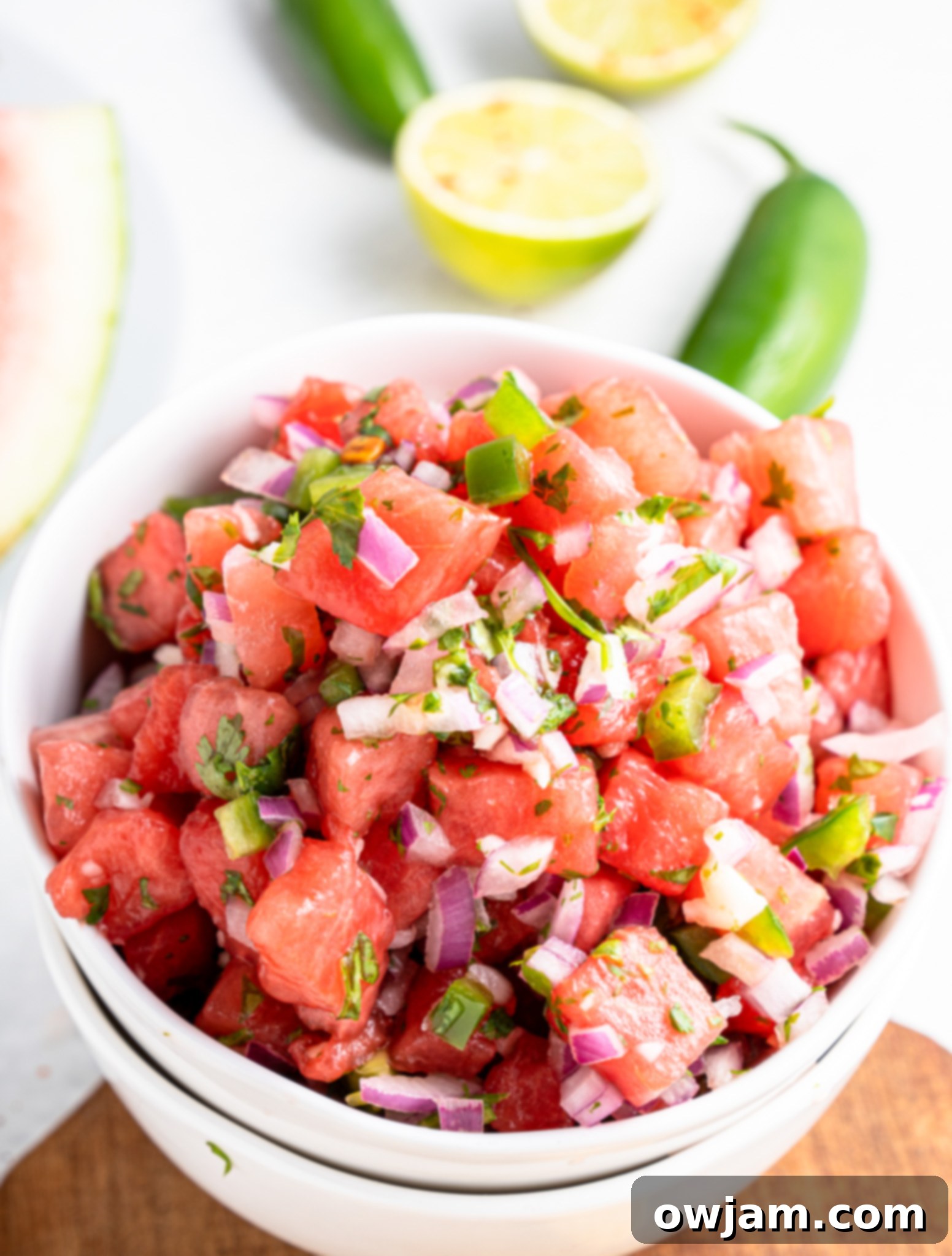 Effortless Watermelon Salsa 3 Easy Watermelon Salsa in a white bowl, garnished with fresh jalapeño slices, highlighting its vibrant colors.