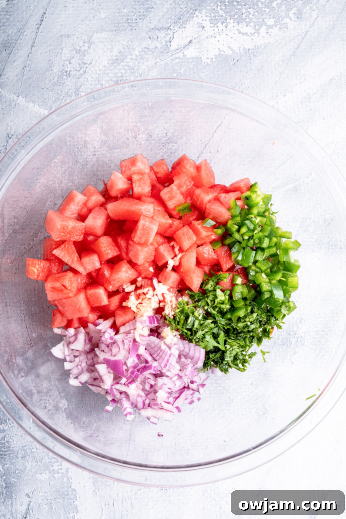 Effortless Watermelon Salsa 7 Freshly chopped ingredients for Easy Watermelon Salsa in a clear glass bowl, before mixing.