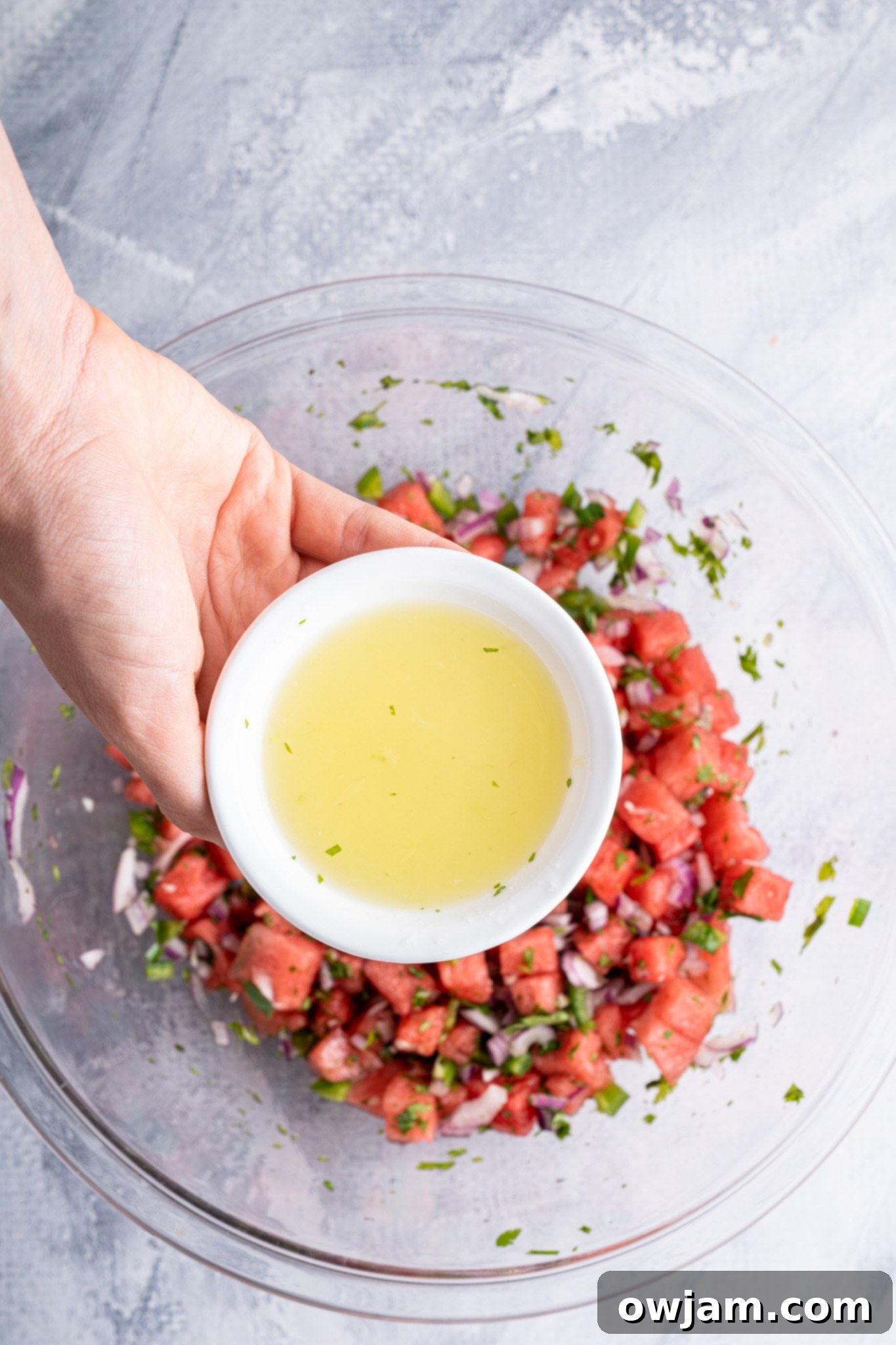 Effortless Watermelon Salsa 8 Lime juice being squeezed over a bowl of Easy Watermelon Salsa, enhancing its fresh flavors.