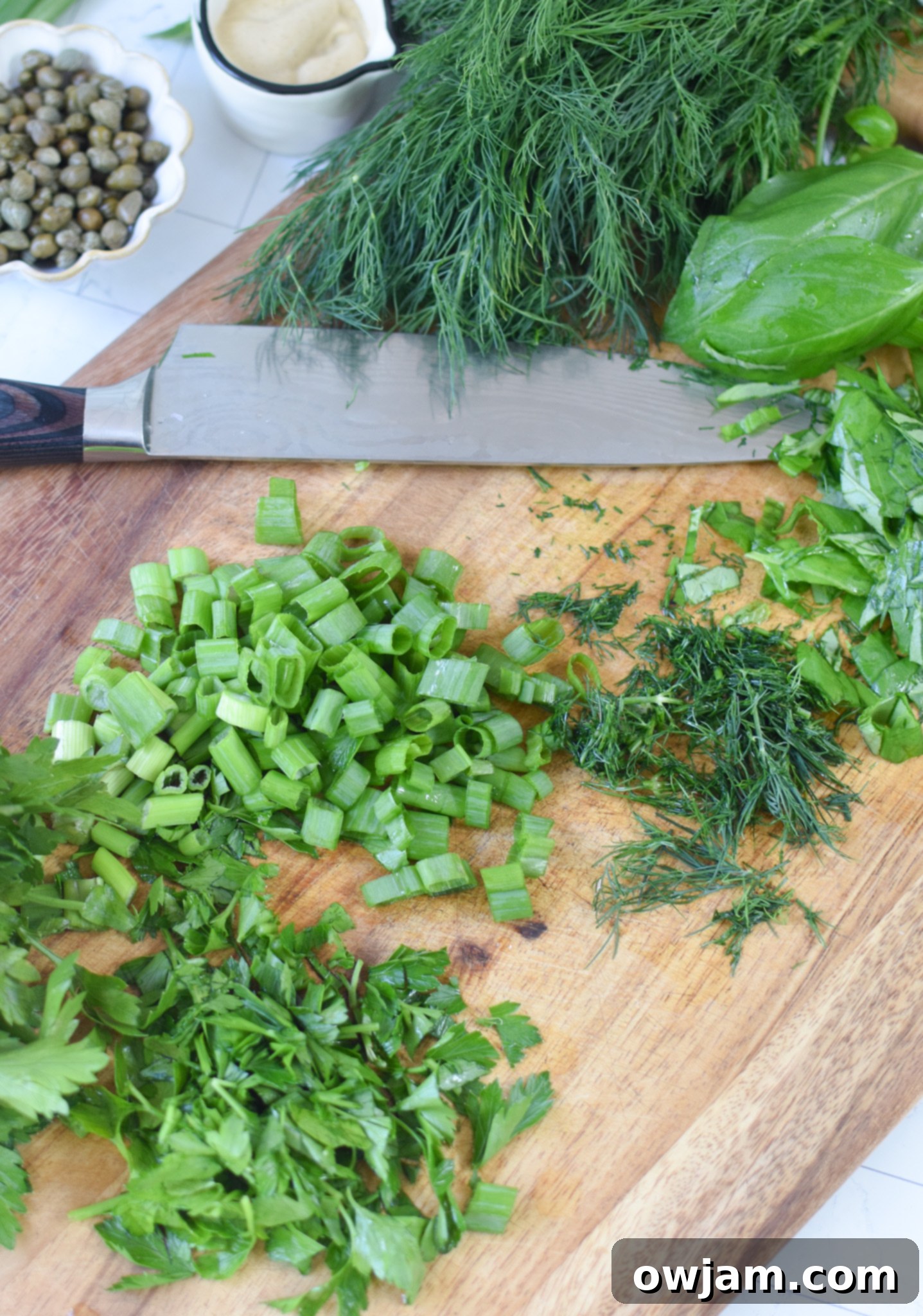 Fresh herbs (parsley, basil, dill) on a cutting board, ready for the No Mayo Potato Salad.