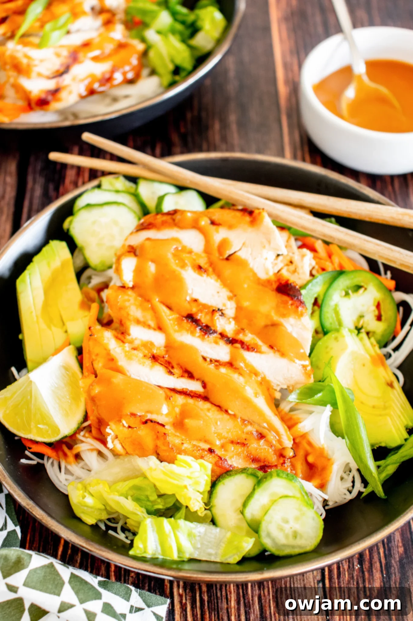 Thai Chicken Noodle Salad with limes. A bowl of Thai chicken noodle salad garnished with fresh lime wedges.