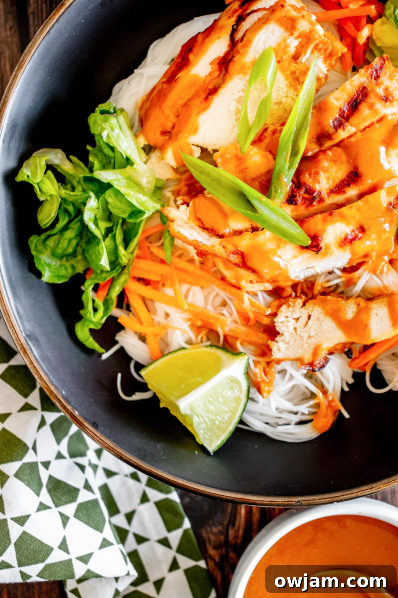 A close-up shot of Thai Chicken Noodle Salad served in a stylish black bowl.