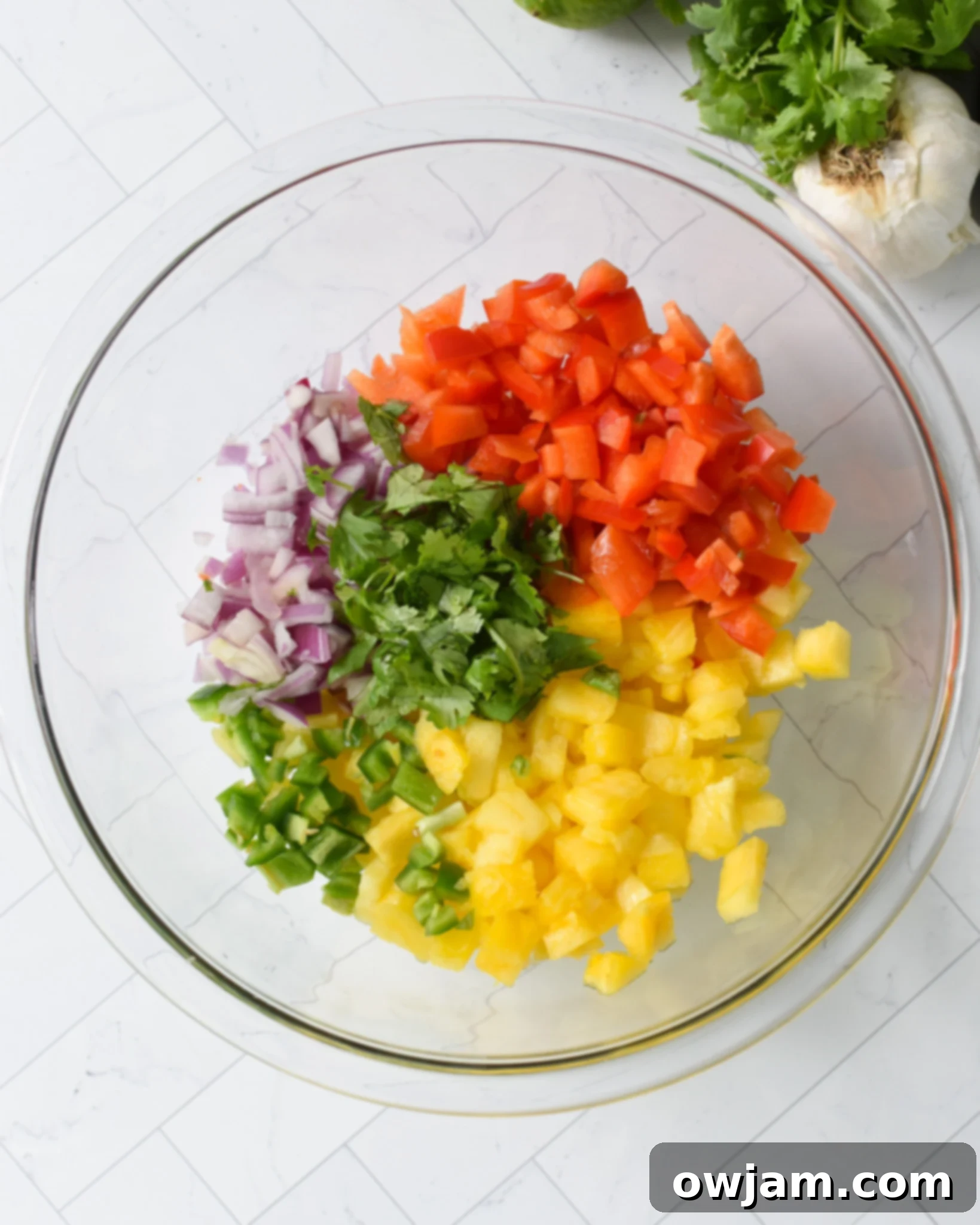 Balsamic Marinated Skirt Steak pineapple salsa being prepared in a clear bowl. 