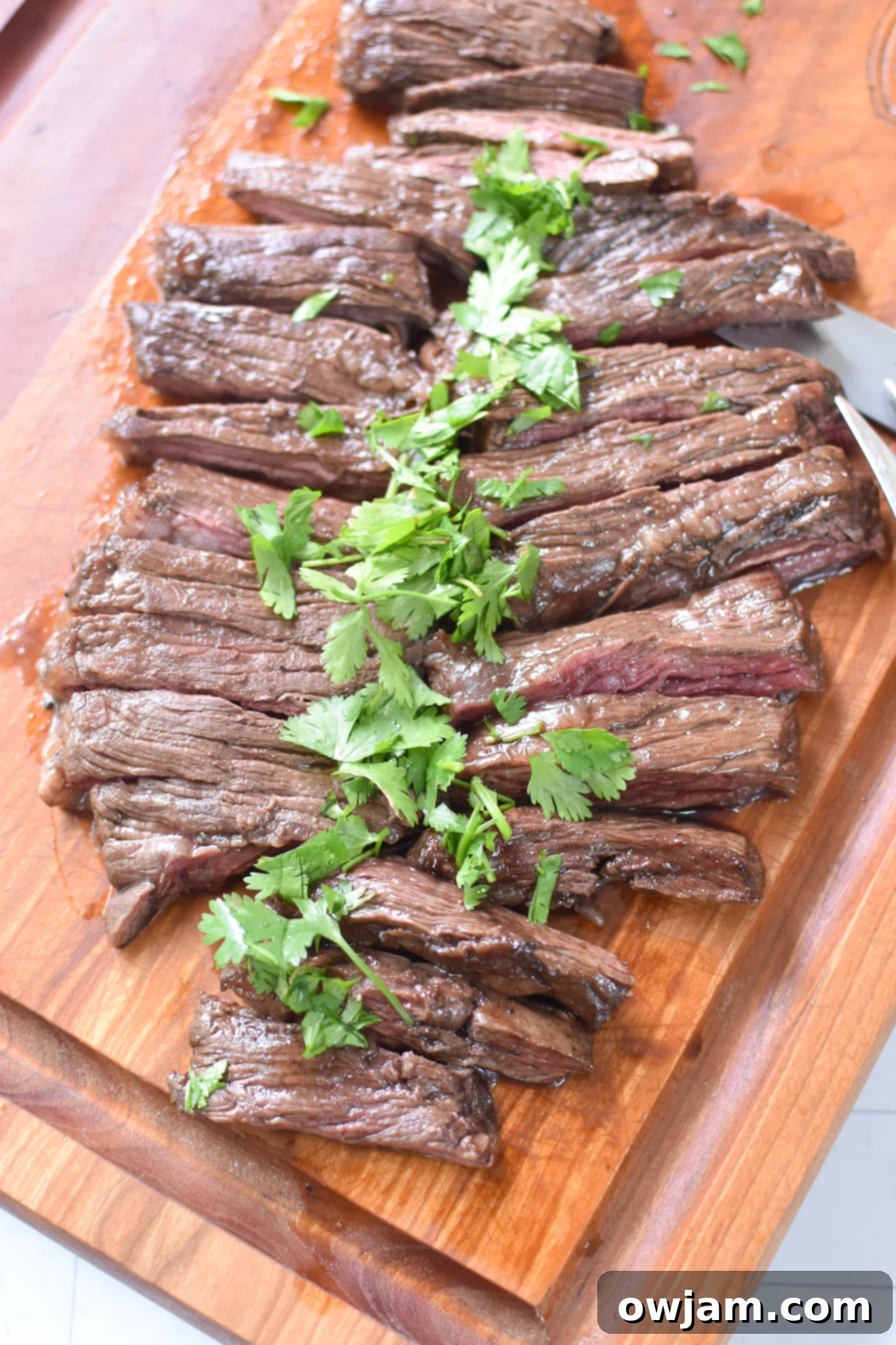 Balsamic Marinated Skirt Steak skirt steak on a cutting board with cilantro. 