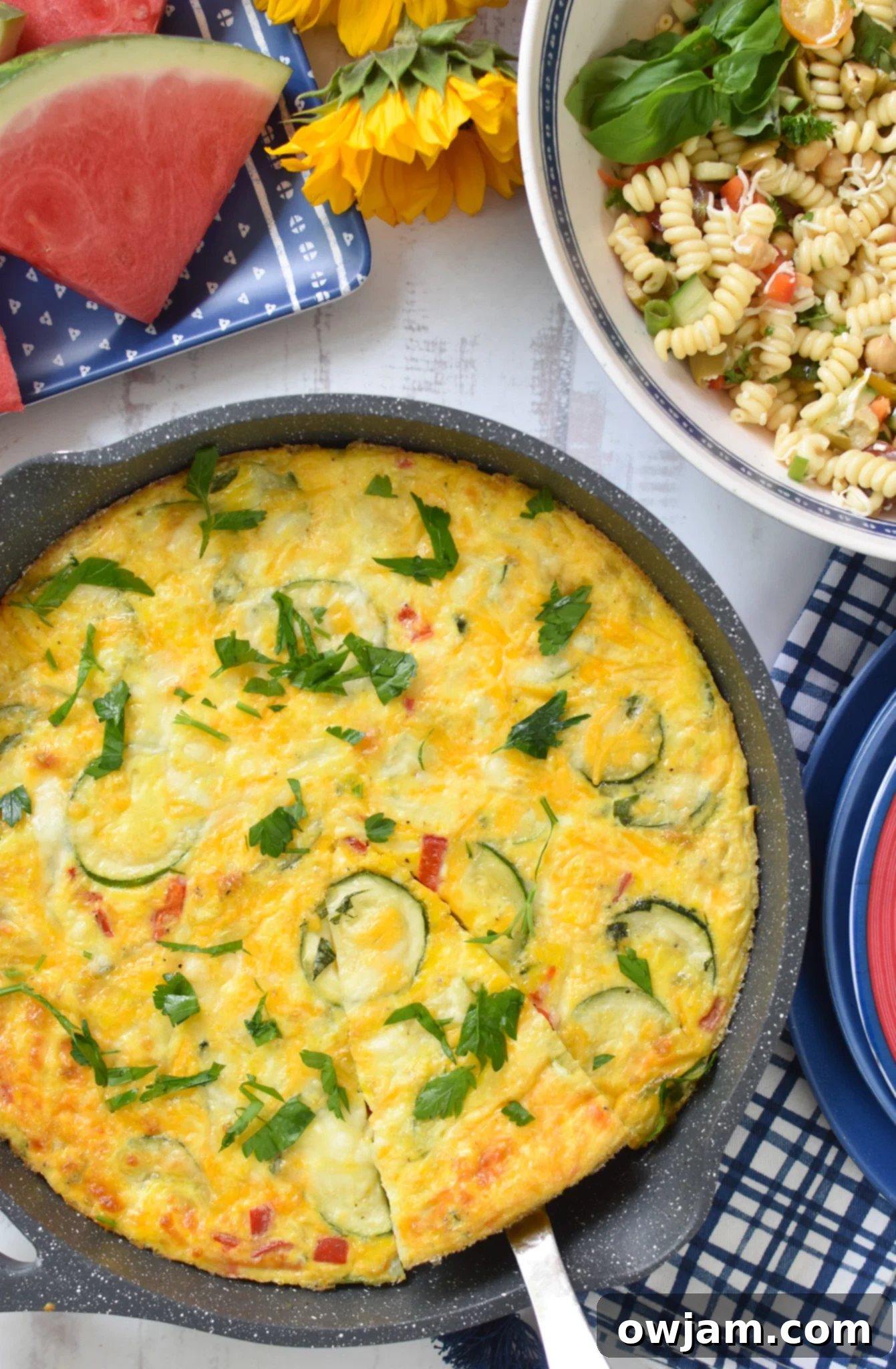 Savory Zucchini Frittata 2 Zucchini Frittata Recipe in a skillet with blue napkins, ready to be served.