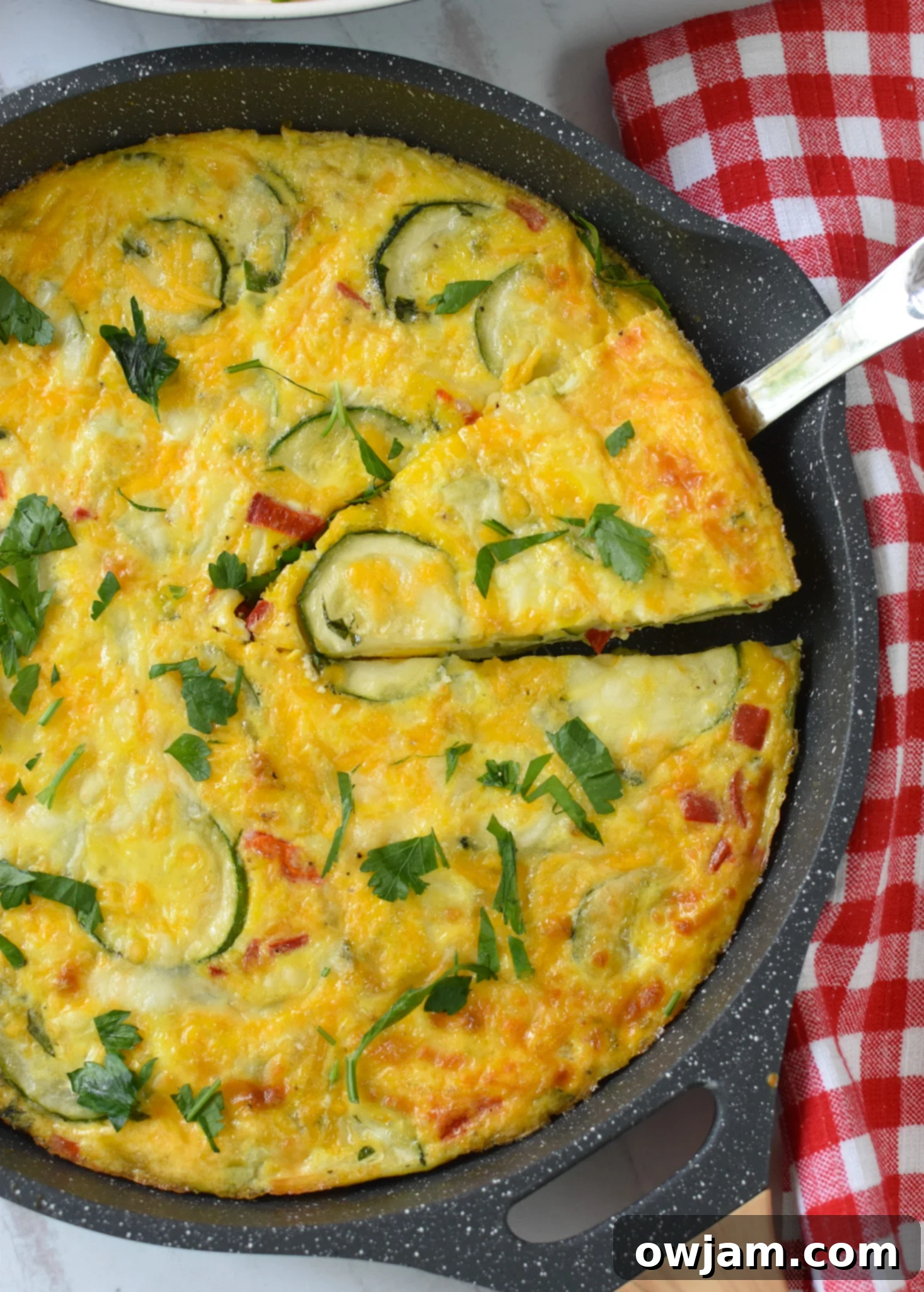 Savory Zucchini Frittata 5 Zucchini Frittata Recipe being sliced with a pie cutter, showing its fluffy texture.
