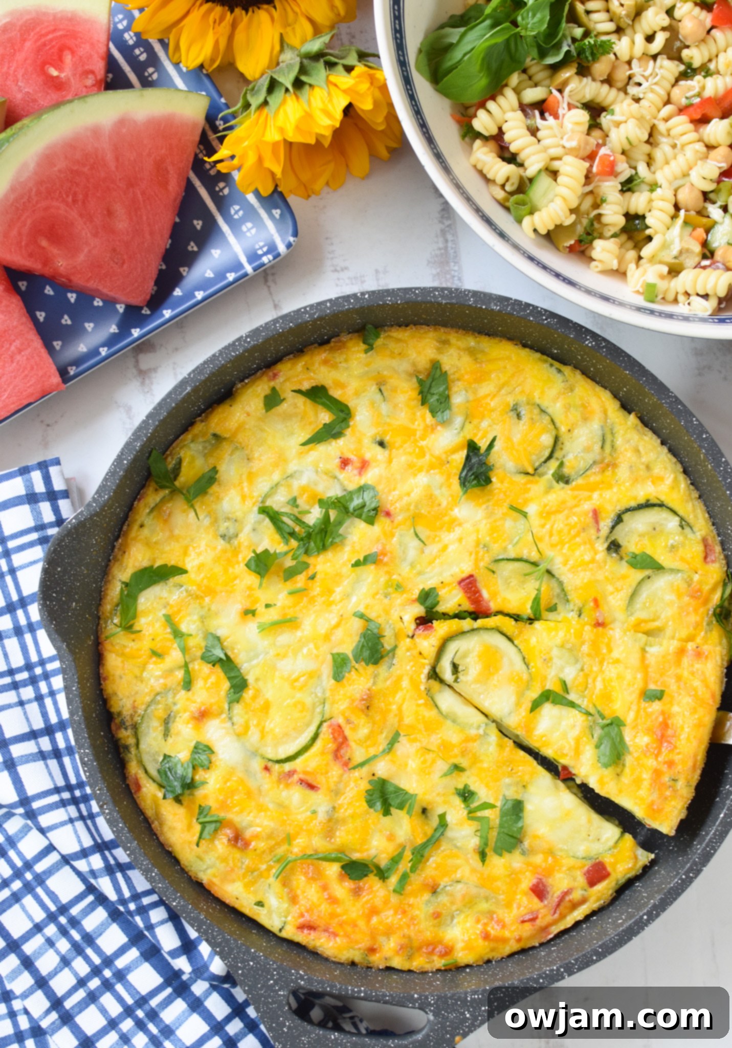 Savory Zucchini Frittata 6 A Zucchini Frittata Recipe cooling on a blue napkin, ready to be sliced and served.