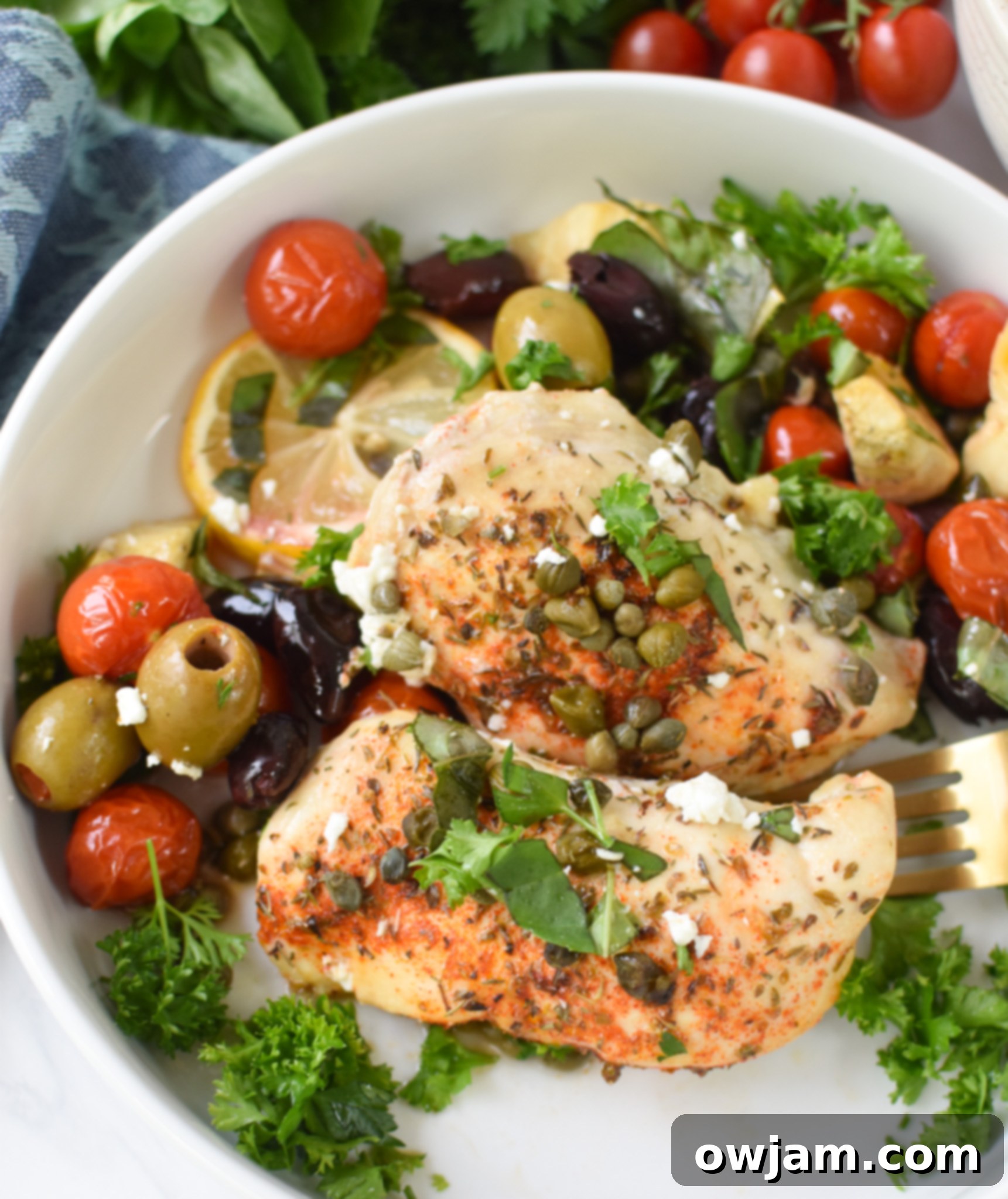 Easy Mediterranean Chicken Skillet 3 A serving of Mediterranean Skillet Chicken in a white bowl, garnished with fresh herbs.