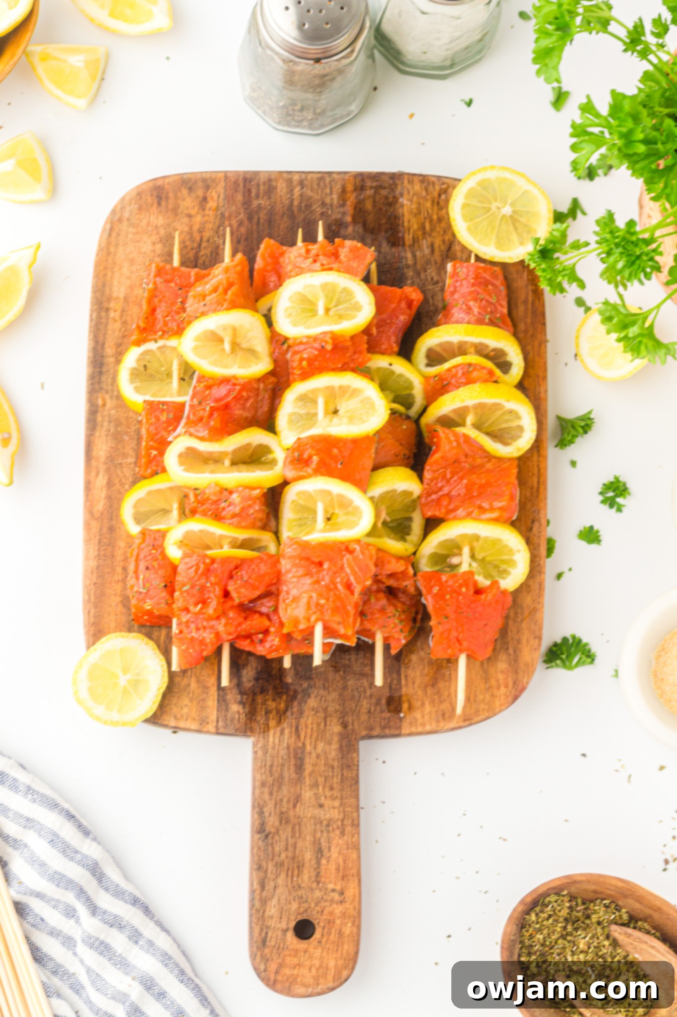 Zesty Lemon Salmon Skewers 8 Easy Lemon Salmon Kabobs assembled on skewers, with salmon and lemon slices ready for cooking.