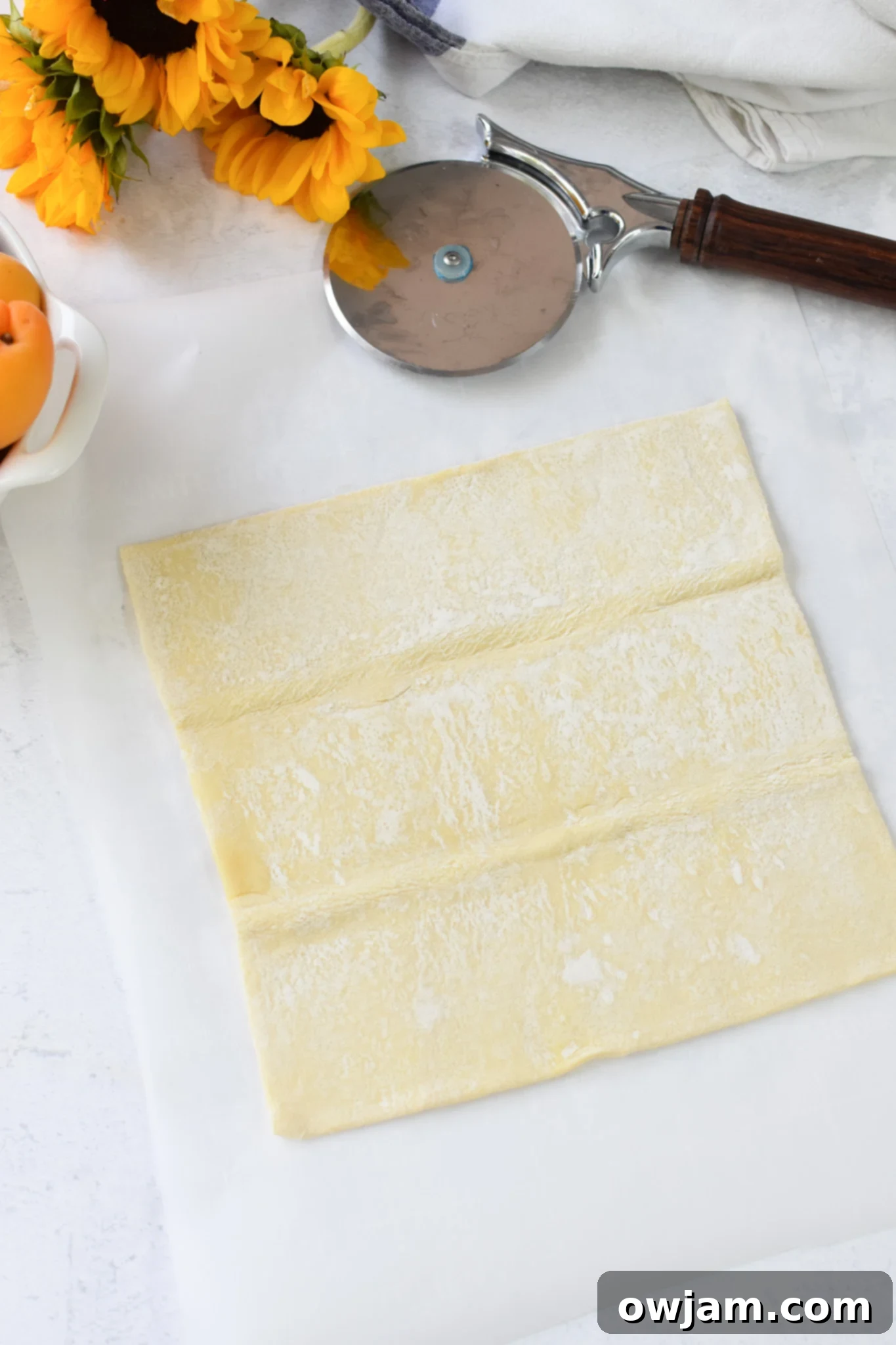 Easy Peach Tart puff pastry on parchment paper. 