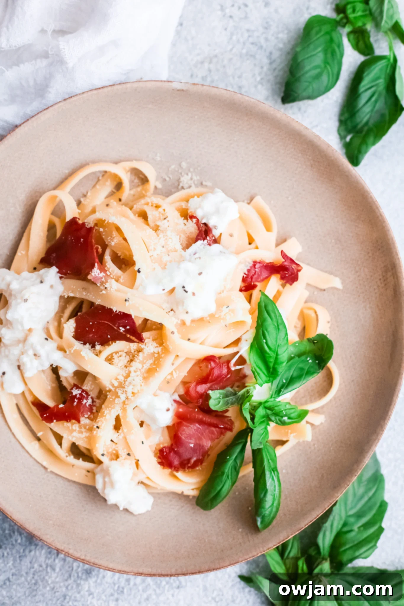 Prosciutto Pasta in a white bowl, garnished with fresh basil.
