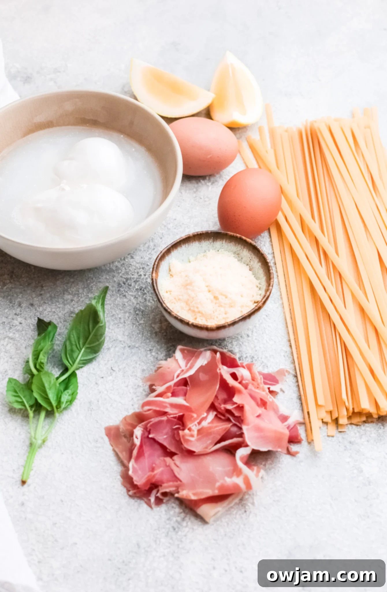Individual ingredients for Prosciutto Pasta laid out on a wooden board.