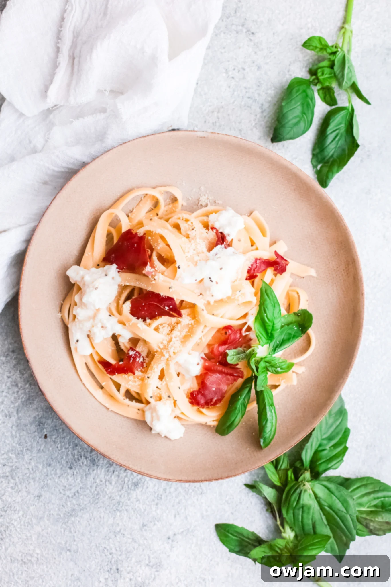 A serving of Prosciutto Pasta on a white plate, garnished.
