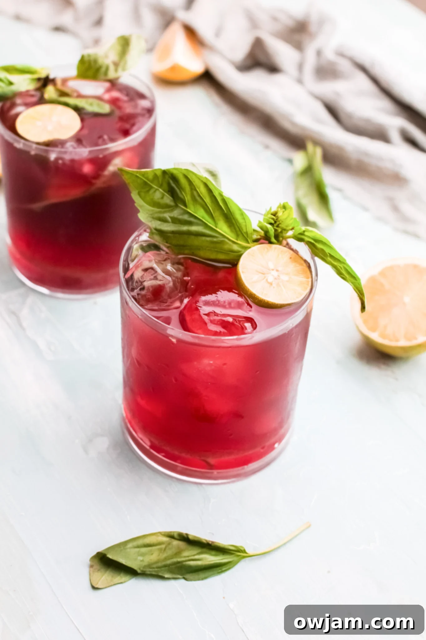 Vodka Cherry Limeade in a glass with basil garnish, ready to be enjoyed.